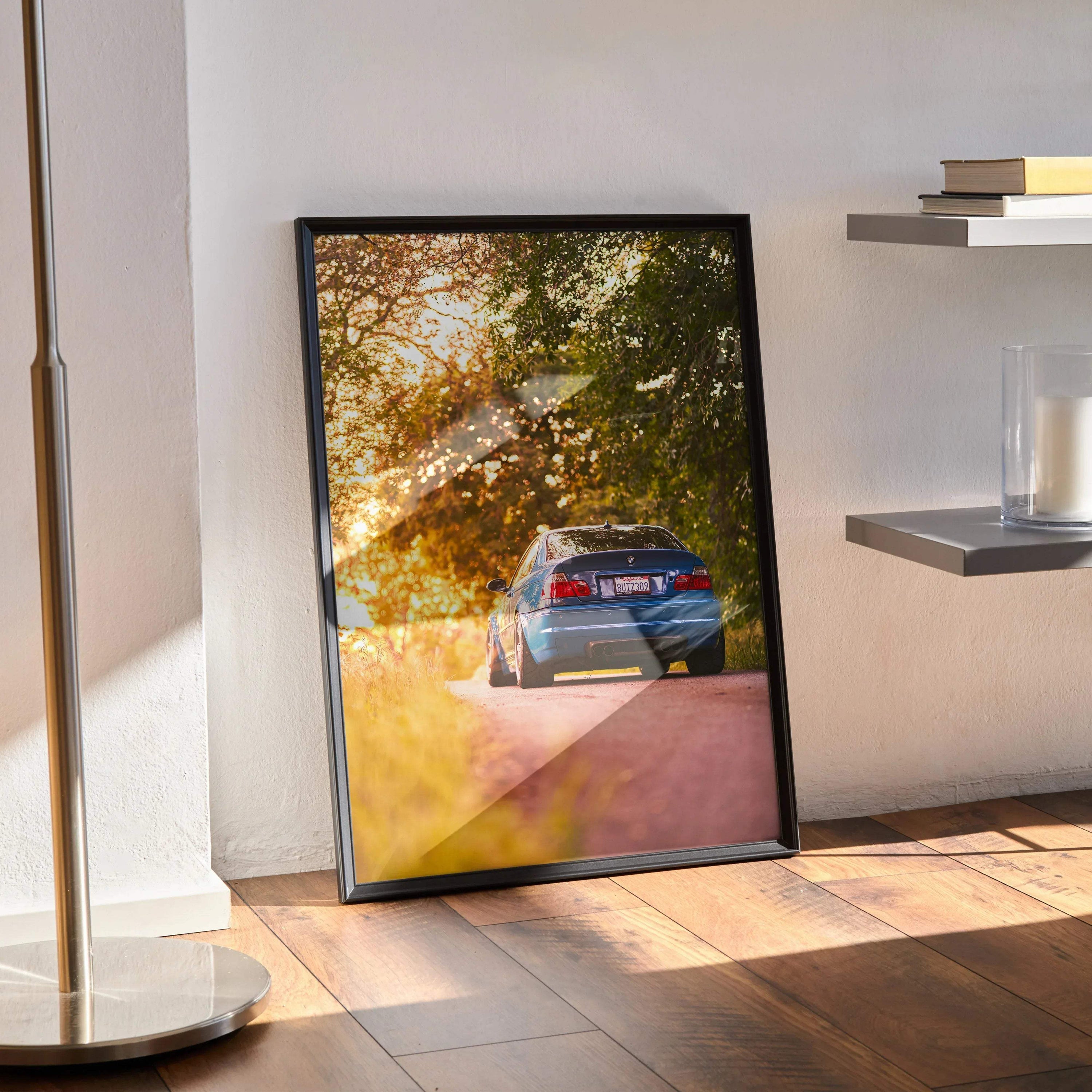 BMW E46 M3 driving through sunlit autumn trees poster wall art with warm golden tones.