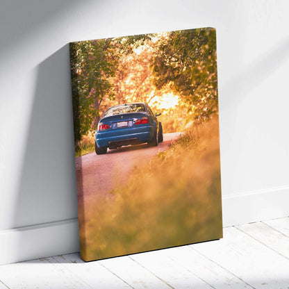 Blue BMW E46 M3 driving on forest road at sunset, vibrant vertical car canvas wall art.