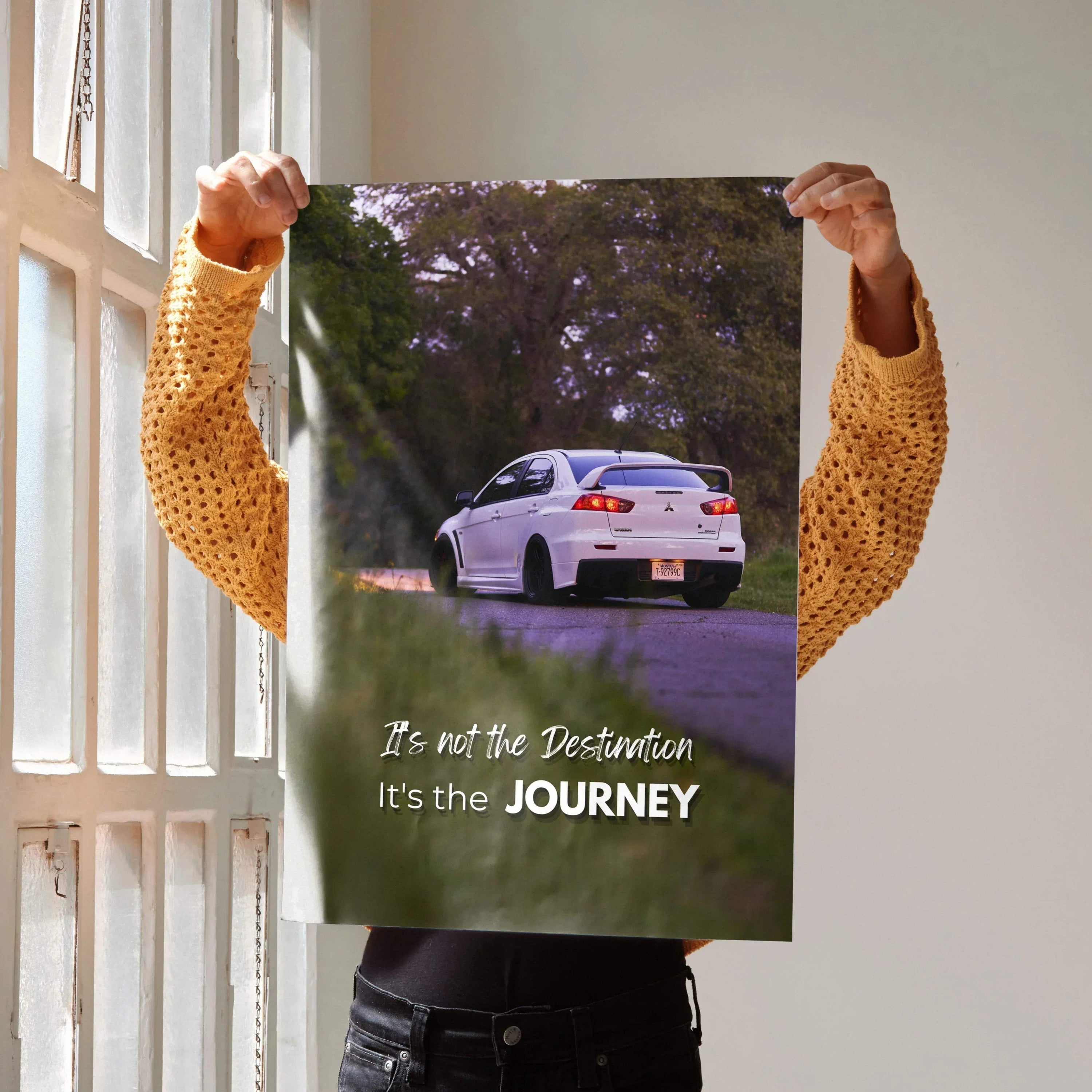 Motivational wall art poster featuring a white Mitsubishi Evo 10 on a winding road with the text "It's not the Destination,.