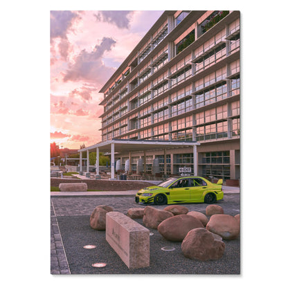 Mitsubishi Evo 9 in bright lime green parked by modern building at sunset poster wall art.
