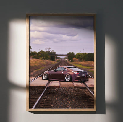 Nissan 350Z poster with sleek car on railroad tracks under cloudy sky, automotive wall art.