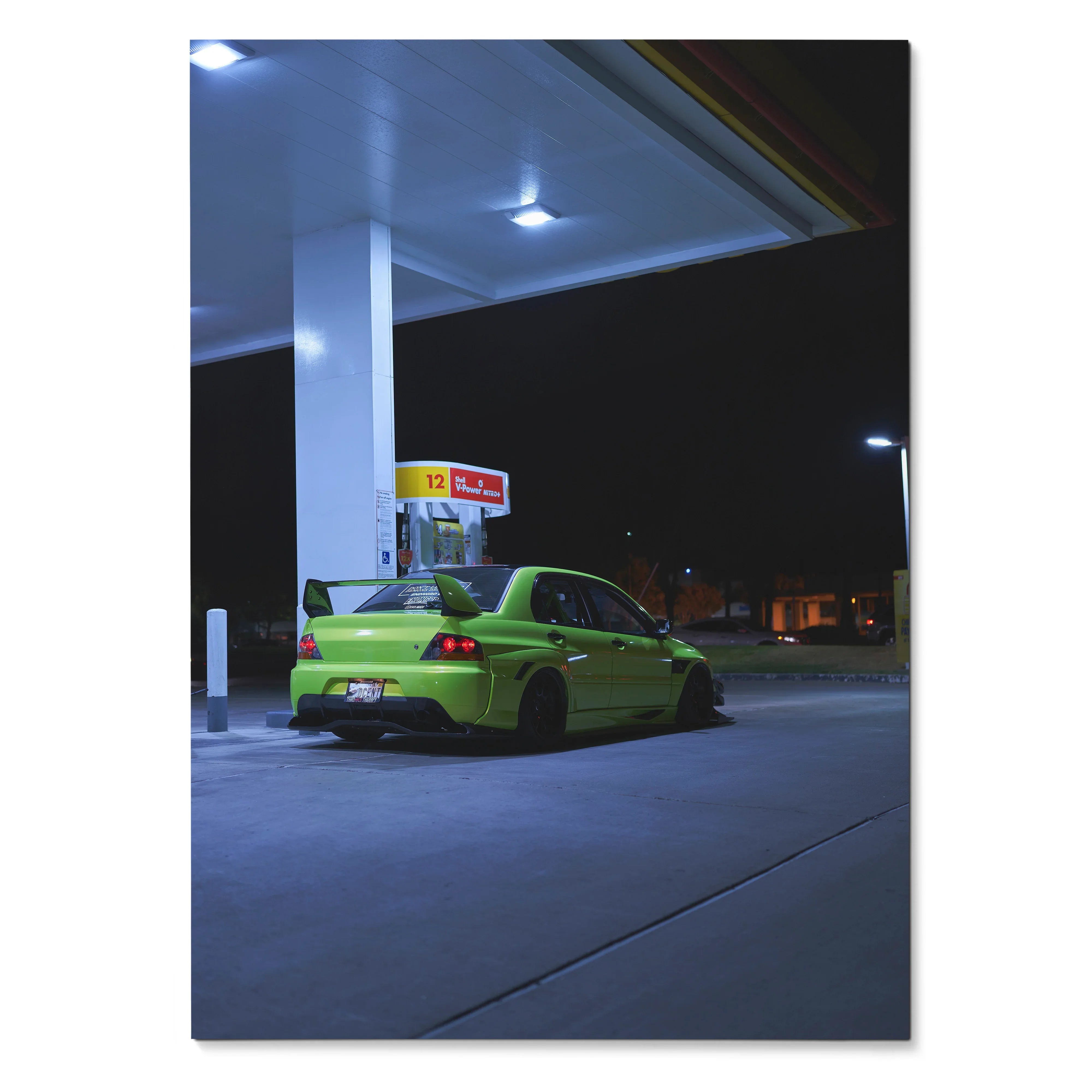 Mitsubishi Evo 9 in bright green parked under gas station lights at night poster wall art.