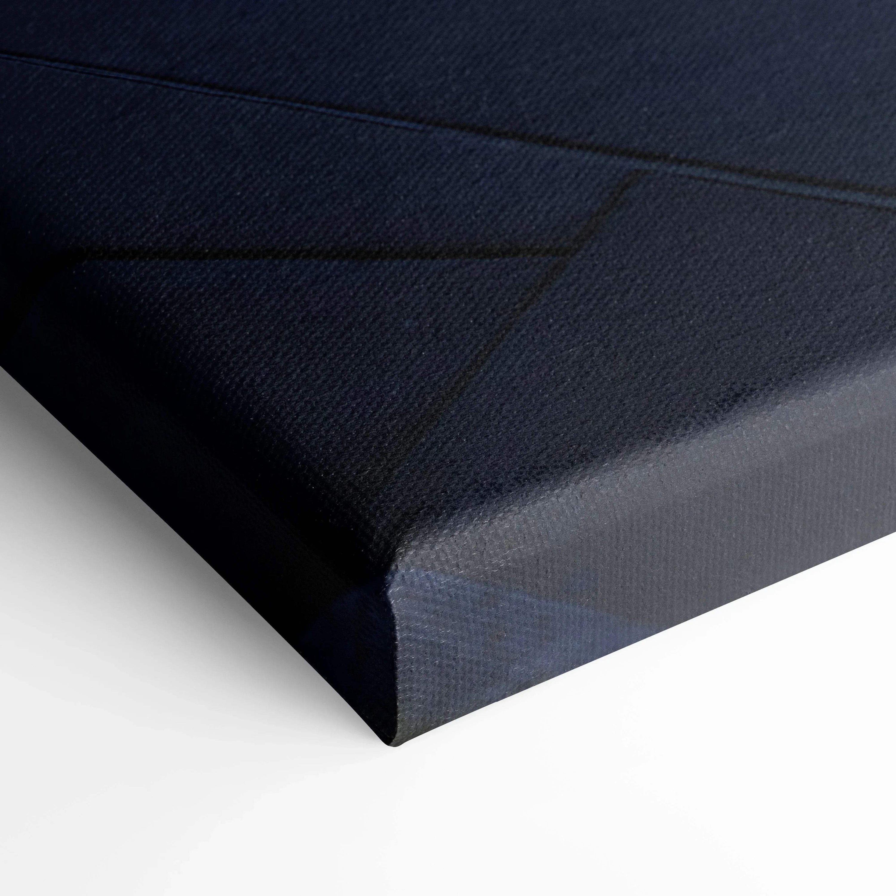 Close-up of black canvas texture on stretched vertical wall art with sharp corner edges.