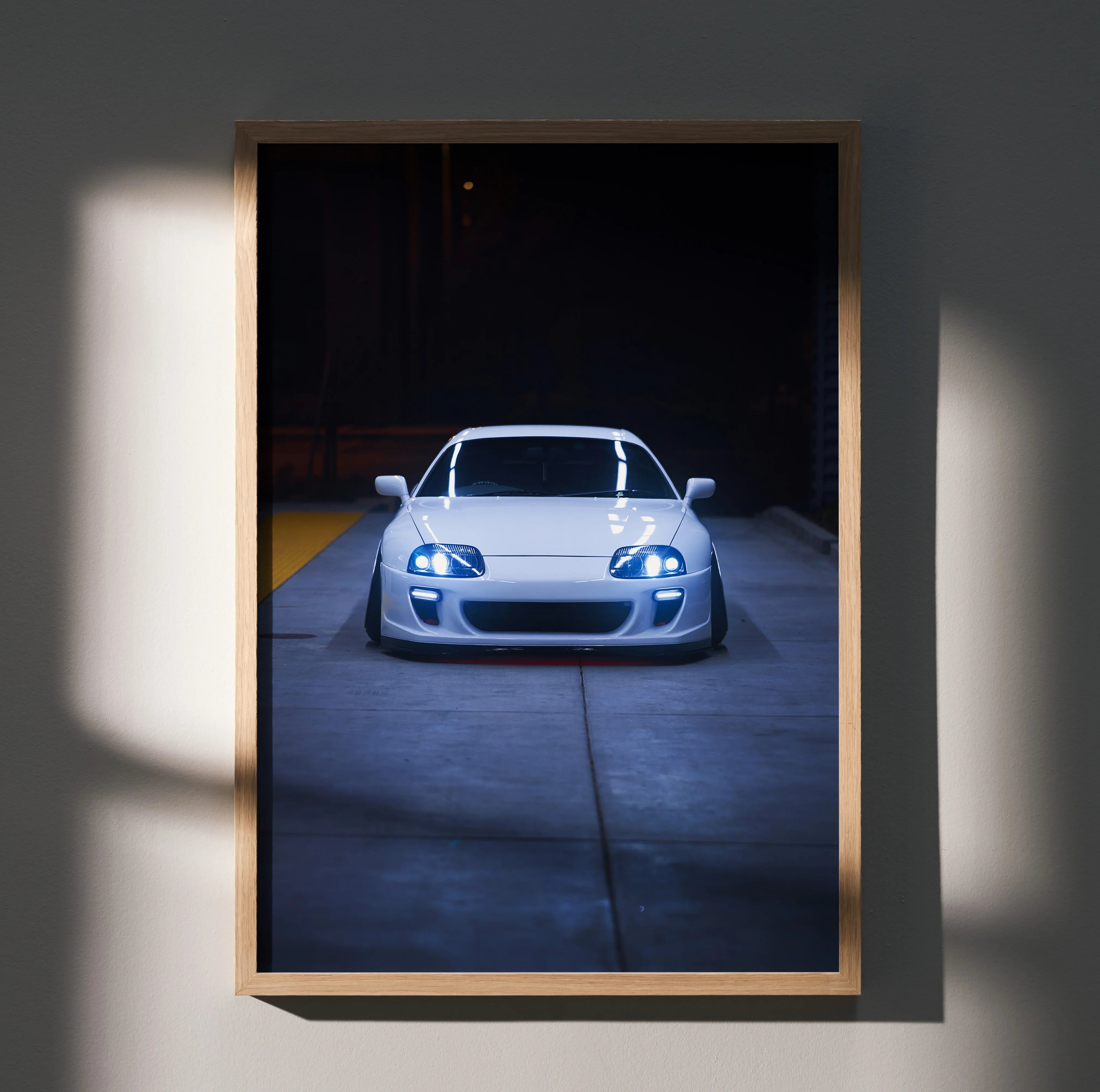 Toyota Supra MK4 white car front view poster wall art in dark urban setting with wooden frame.
