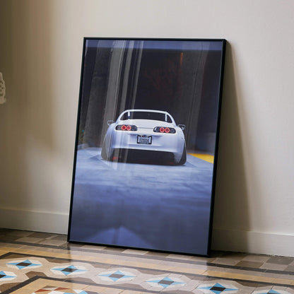 Toyota Supra MK4 JDM rear view poster wall art with black frame, urban background, and floor reflections.
