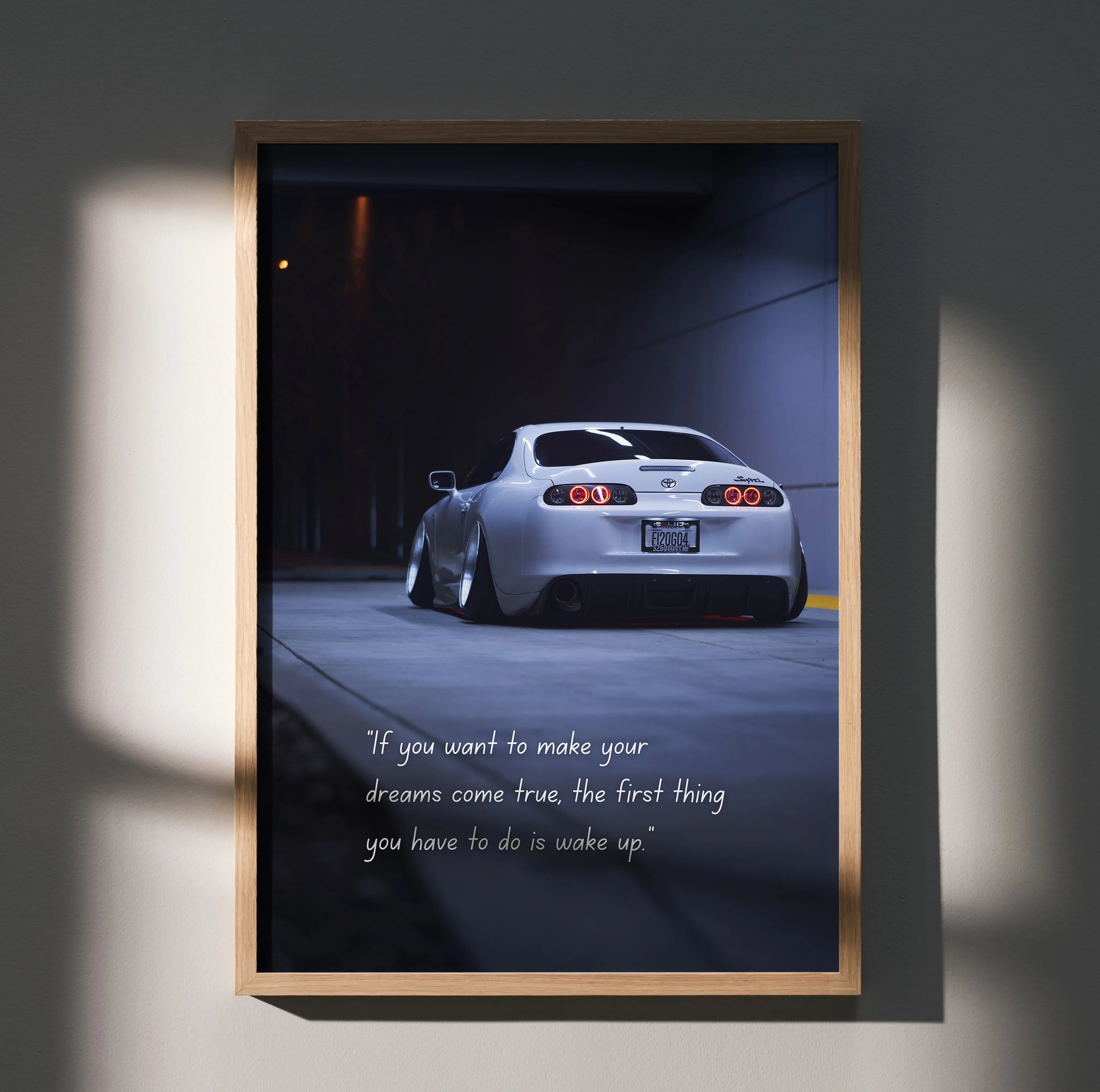 Toyota Supra Mk4 poster wall art featuring rear view of white car with motivational text in dark urban setting.
