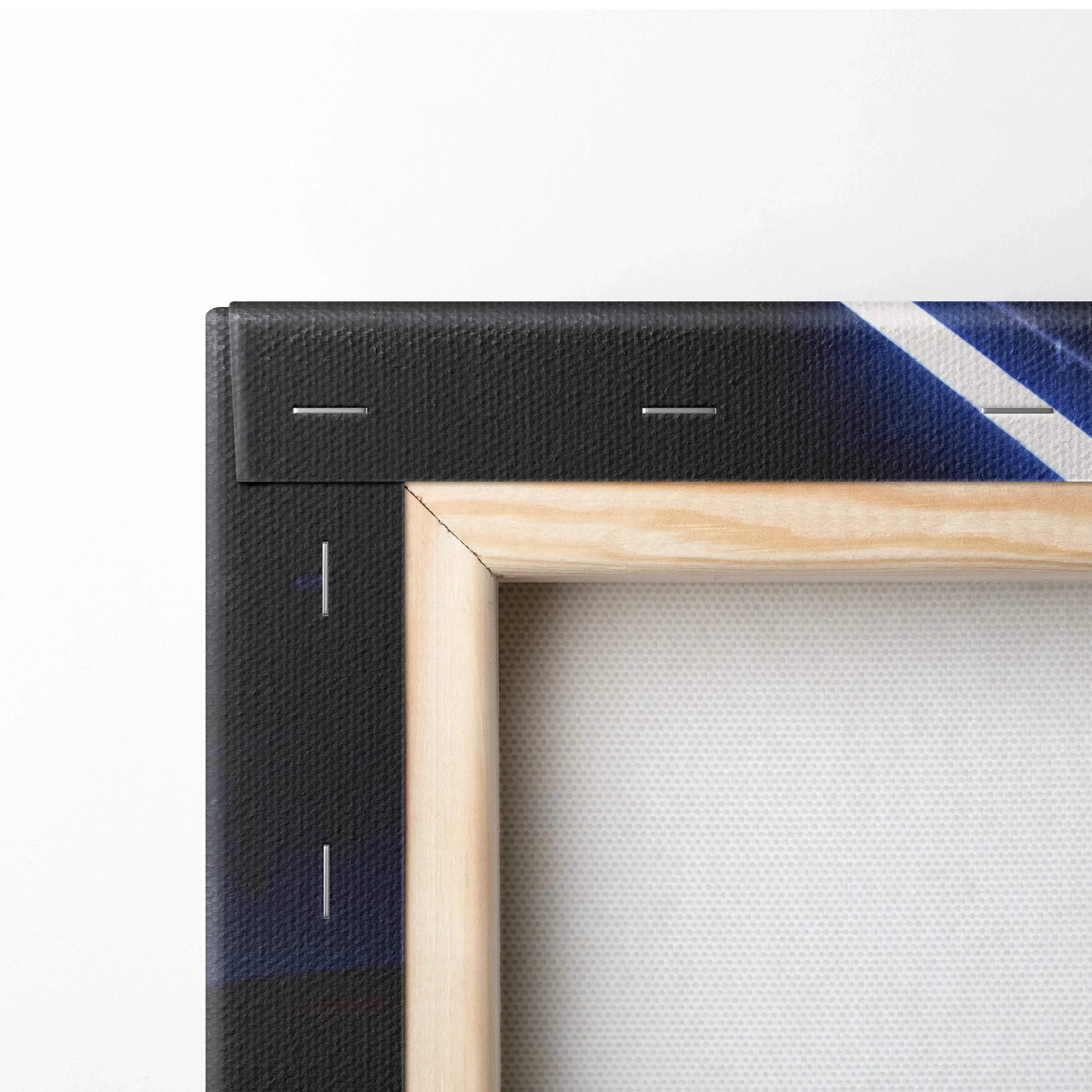 Close-up of wooden frame and black edge on vertical canvas wall art with blue design details.