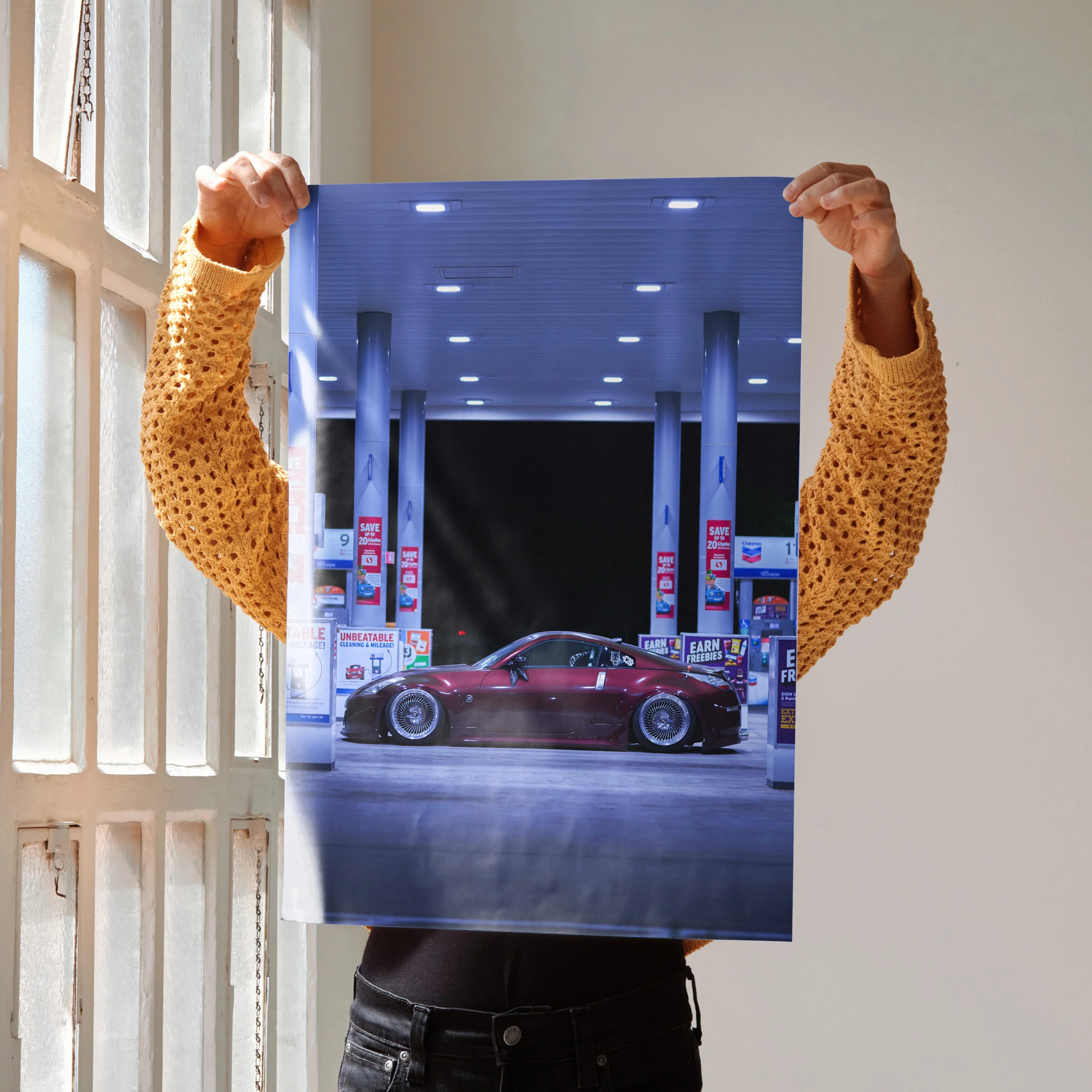 Nissan 350Z poster showing red sports car at gas station wall art with night lighting.