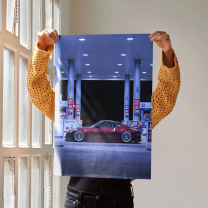 Nissan 350Z poster showing red sports car at gas station wall art with night lighting.