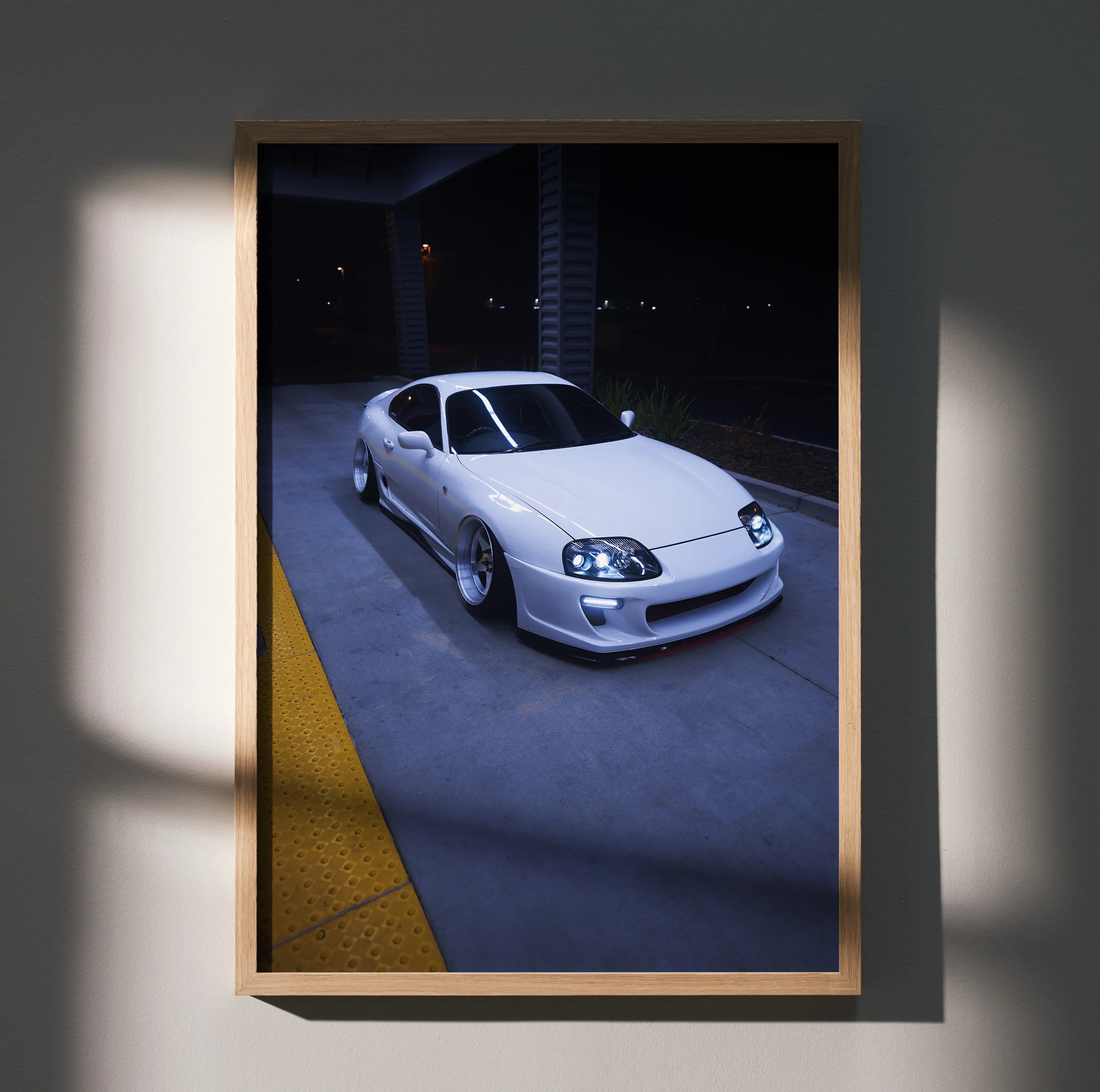 Toyota Supra MK4 white sports car parked under streetlights poster wall art in wooden frame.