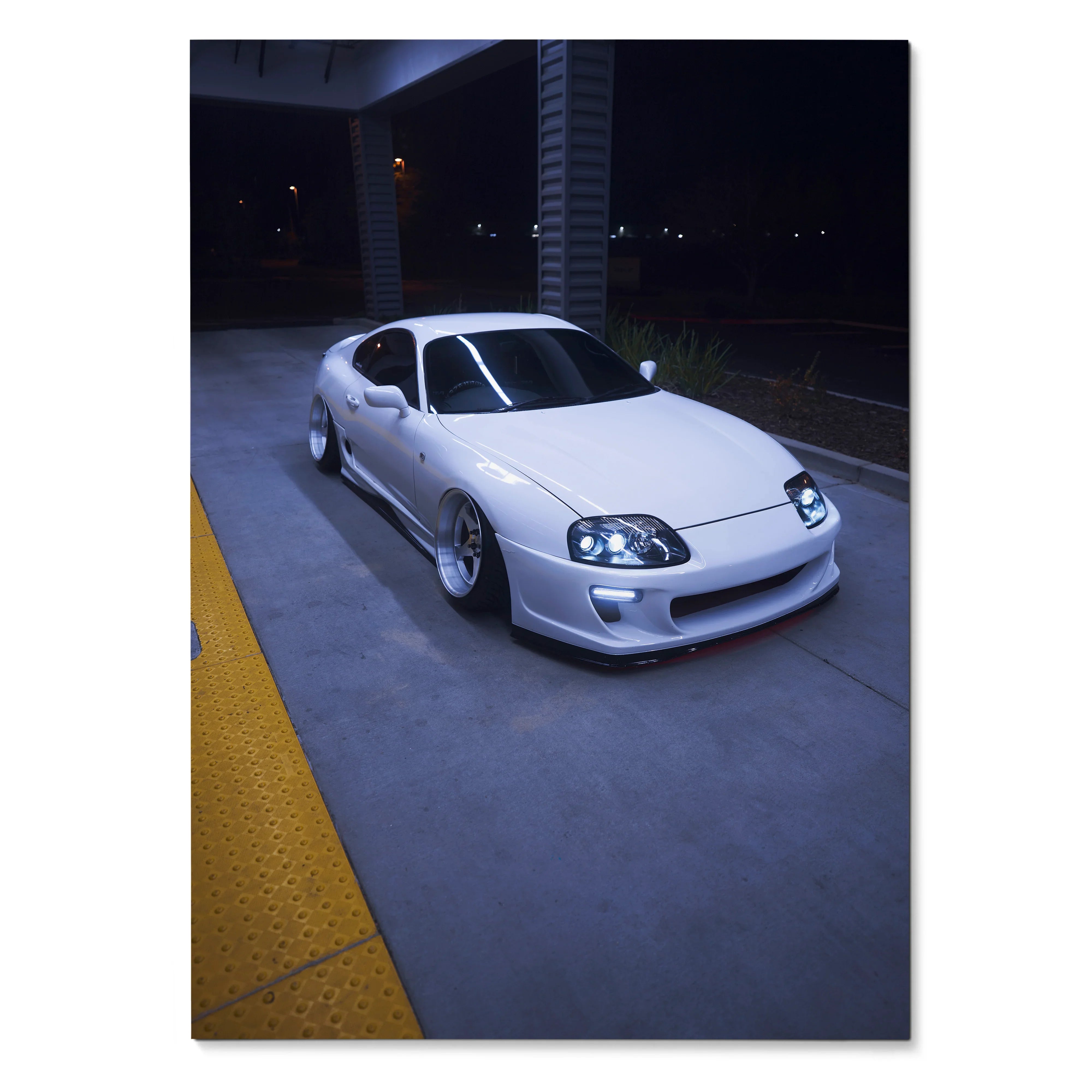 Toyota Supra MK4 white sports car at night poster wall art with urban backdrop.