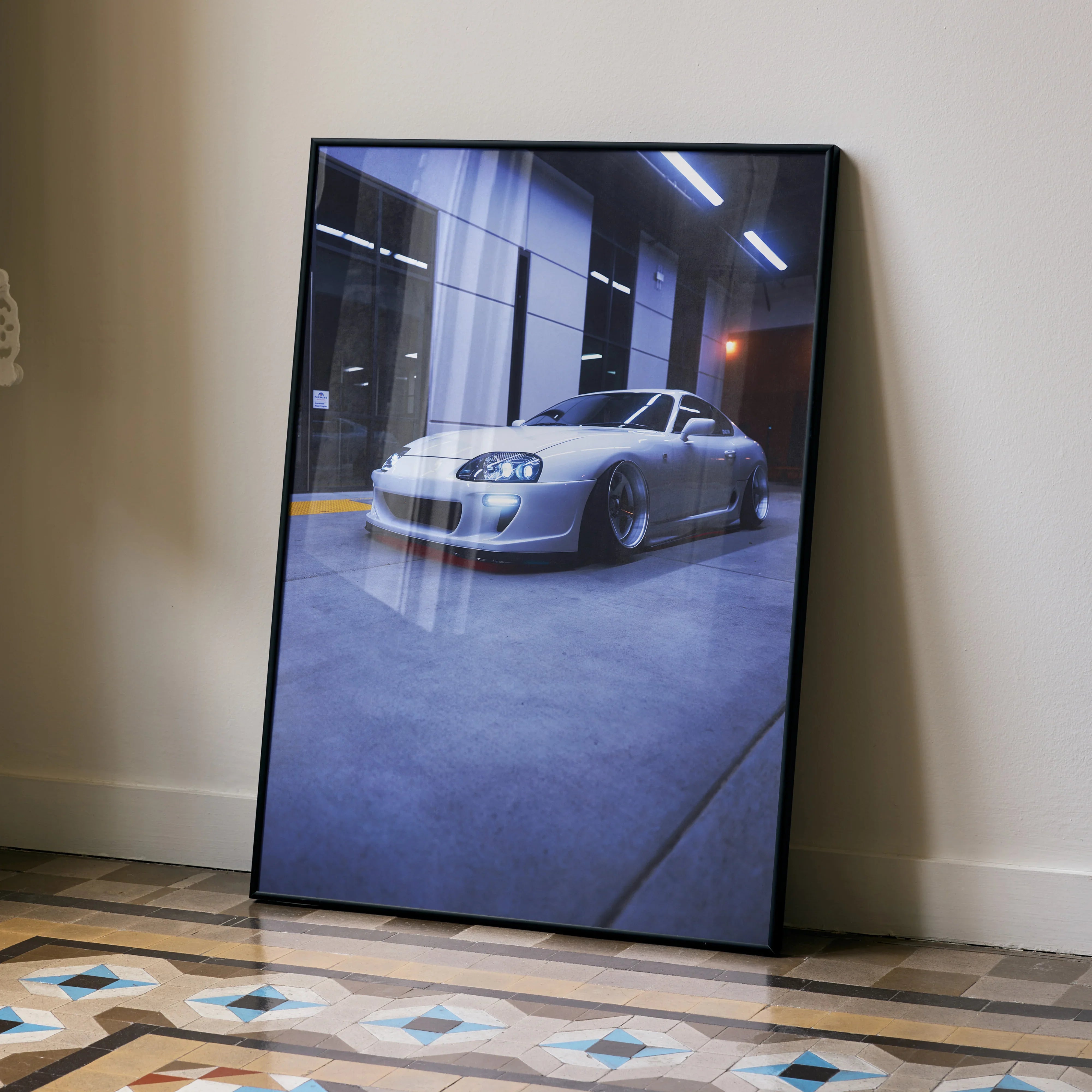 Toyota Supra MK4 gray sports car parked inside garage Poster wall art in black frame leaning against wall.