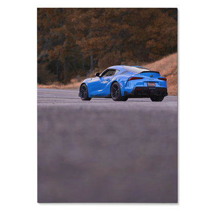 Blue Toyota Supra MK5 sports car on road with autumn trees backdrop poster wall art.