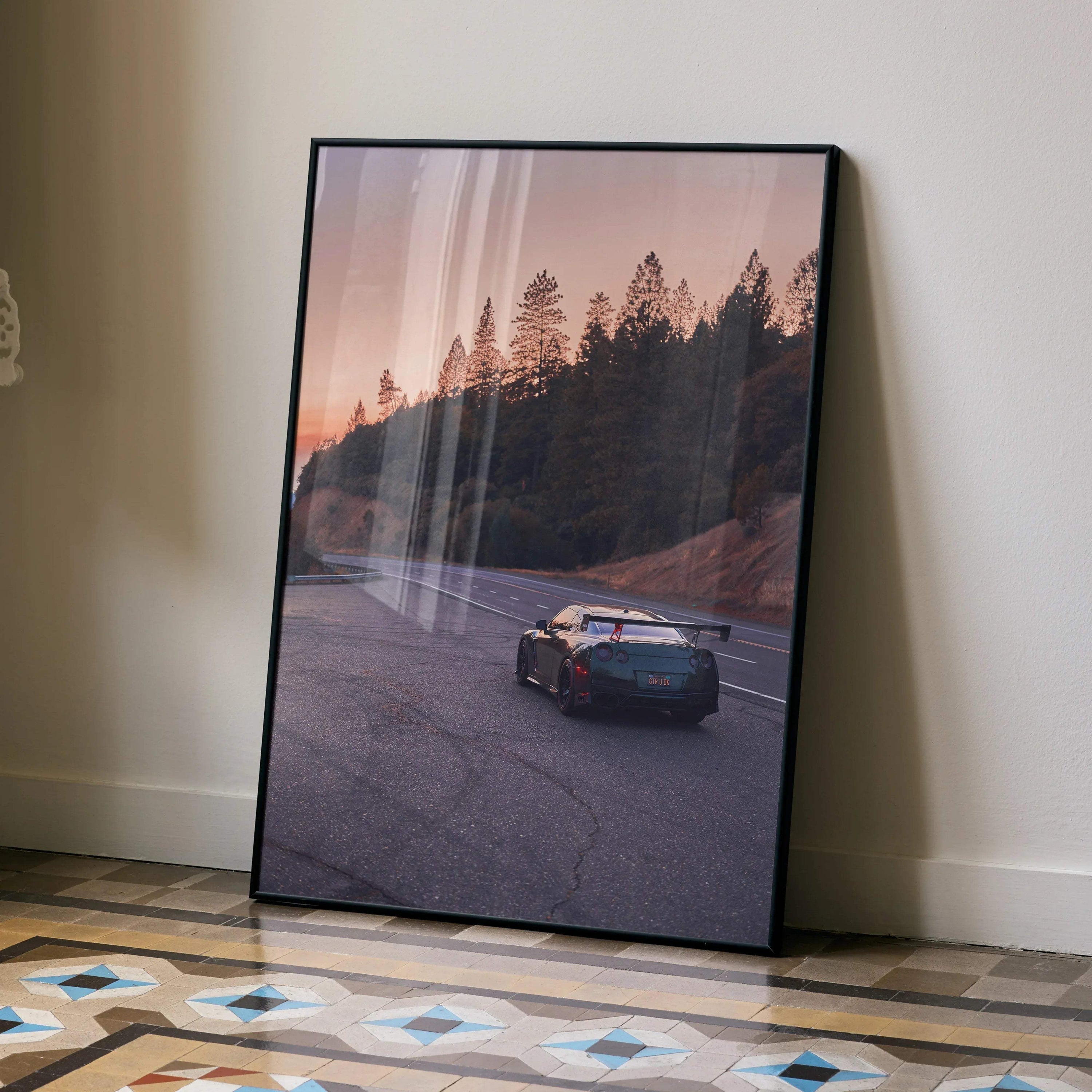 Nissan GTR R35 poster featuring a sleek sports car on a forested road at sunset, framed wall art.