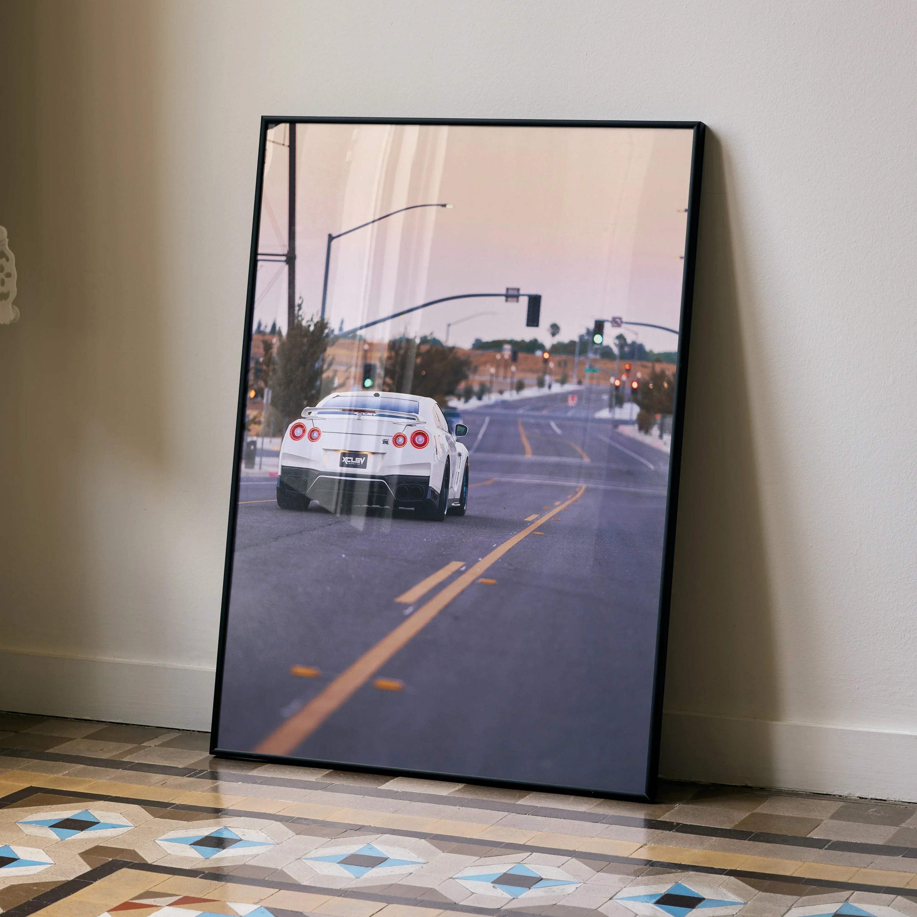 Nissan GTR R35 poster wall art featuring rear view of white sports car on city street at sunset.