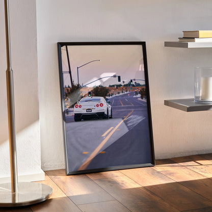 Nissan GTR R35 poster showing rear view on street, framed wall art leaning against white wall.