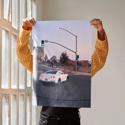 White Nissan GTR R35 driving at an urban intersection poster wall art.