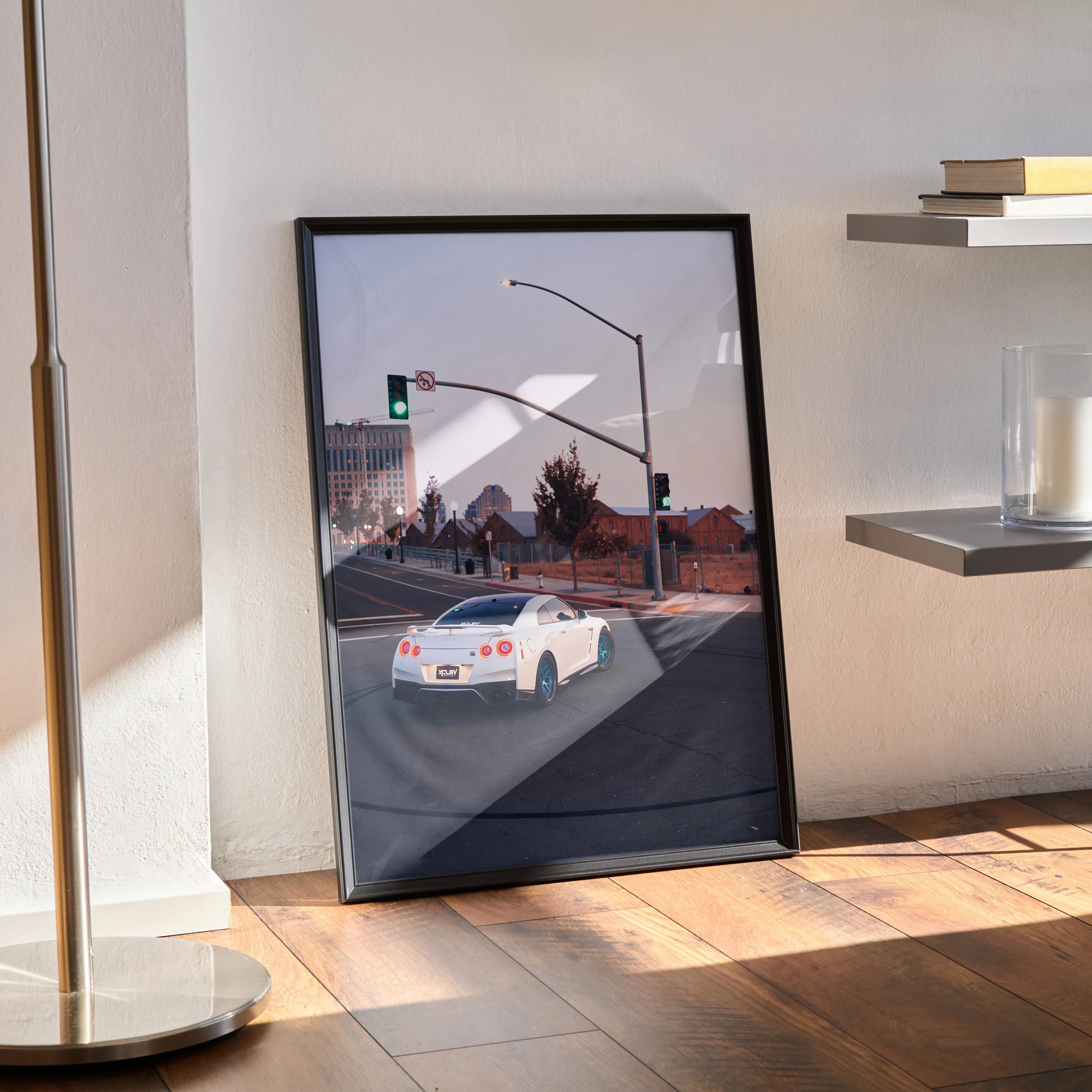 Framed Nissan GTR R35 art poster leaning against wall, modern street scene, sleek car design wall art.