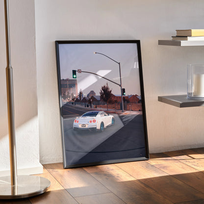 Framed Nissan GTR R35 art poster leaning against wall, modern street scene, sleek car design wall art.