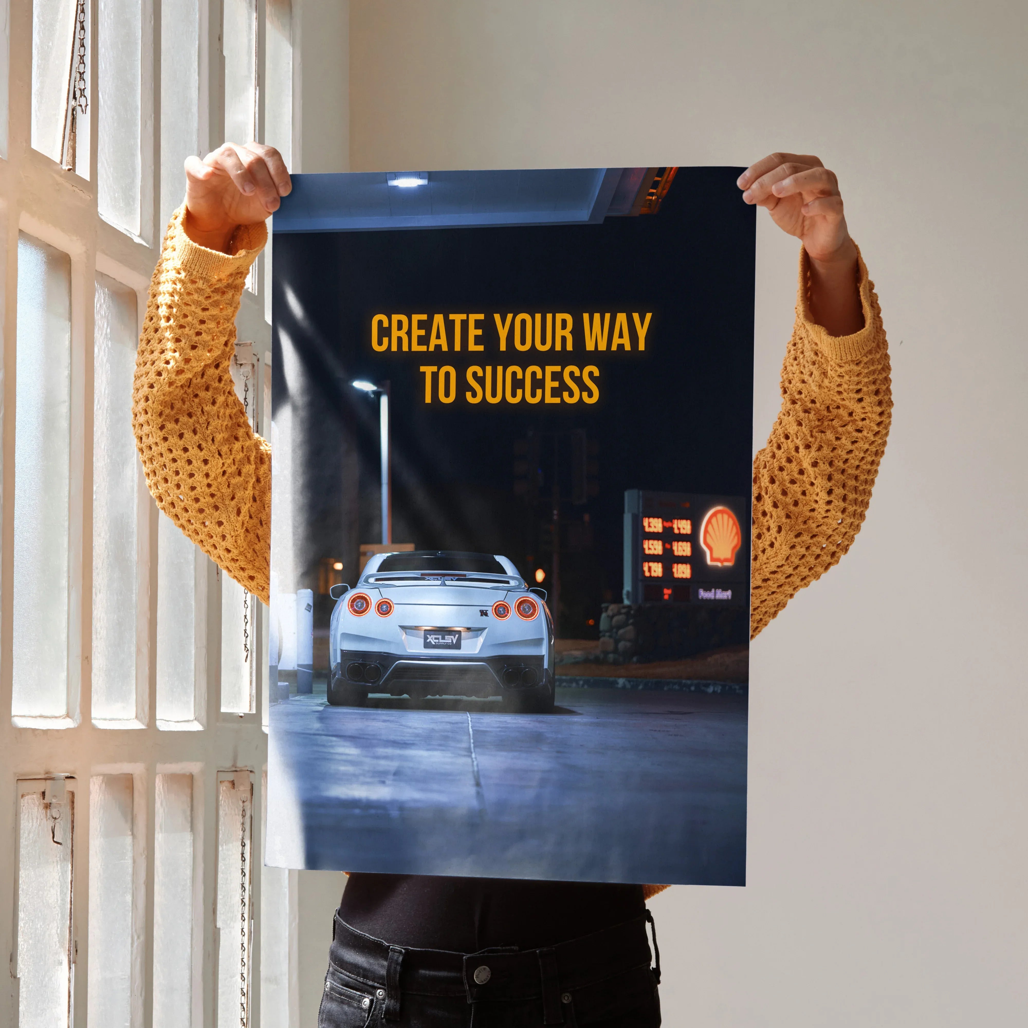 Motivational poster wall art featuring Nissan R35 GT-R with yellow text "Create Your Way to Success" on dark background.