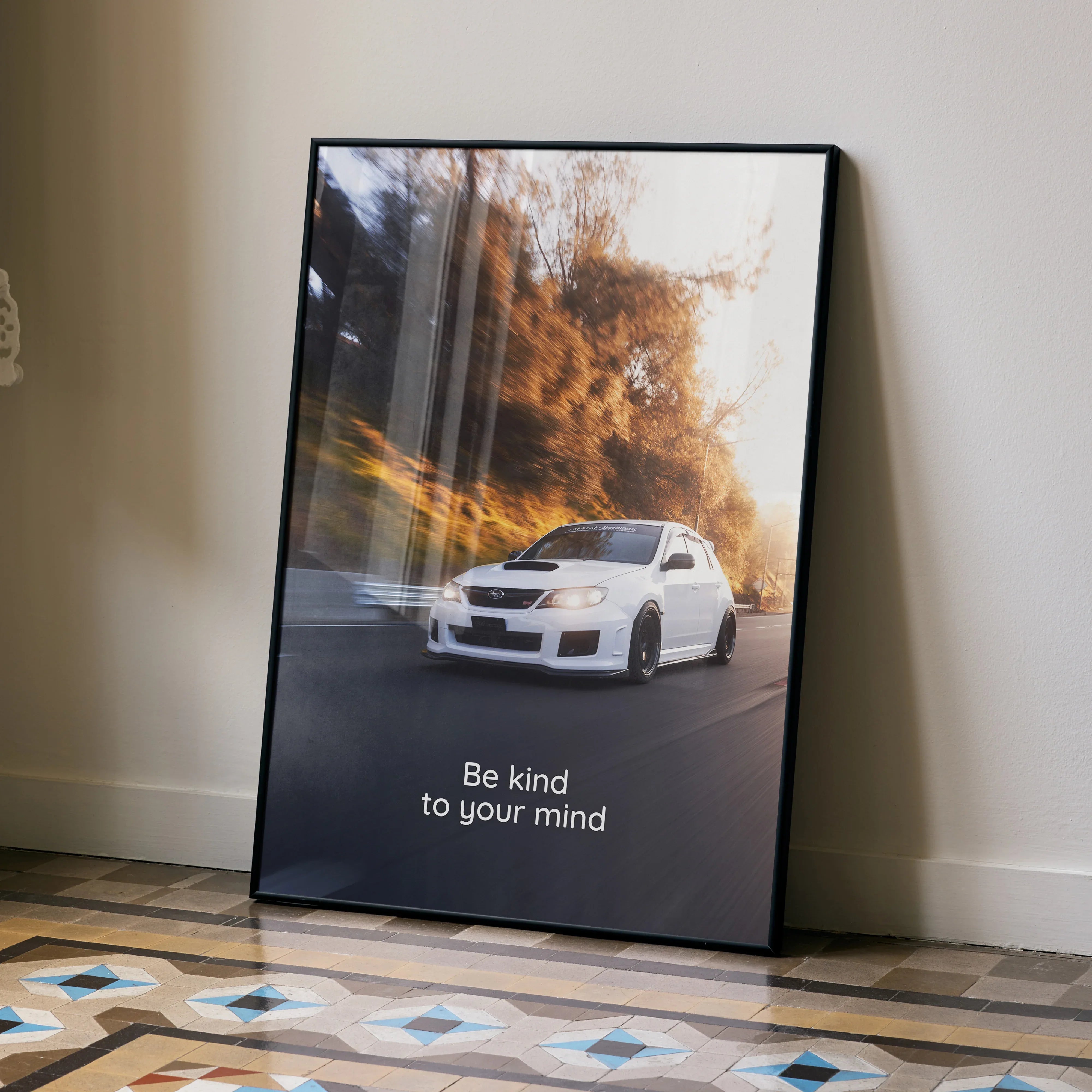 Motivational poster wall art featuring a white Subaru WRX STI on a winding road with inspiring text "Be kind to your mind".