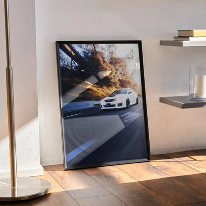 Subaru WRX STI high-resolution automotive art poster in black frame leaning against wall, showcasing dynamic car on winding.