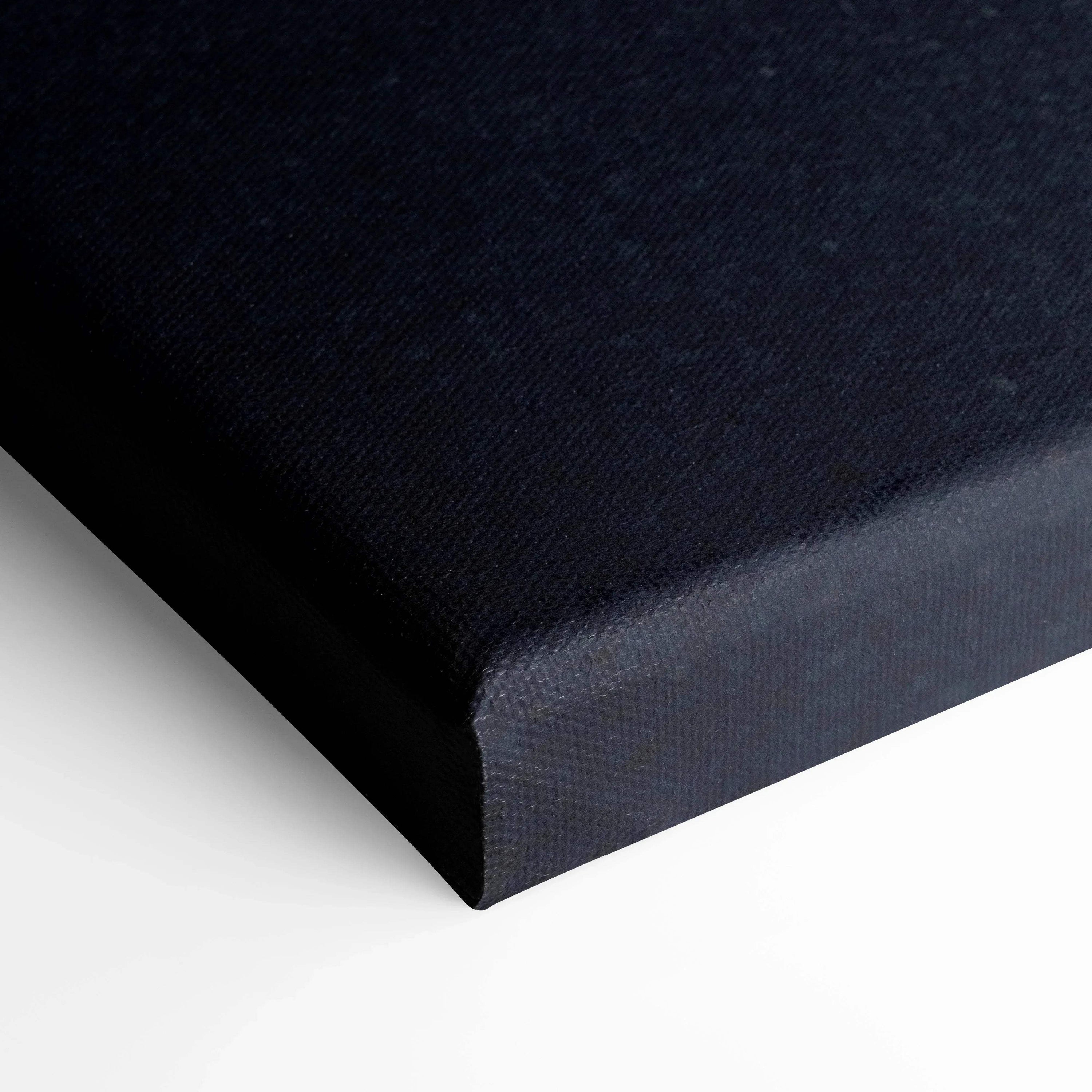 Corner close-up of black canvas wall art with textured fabric wrap on stretcher bars.