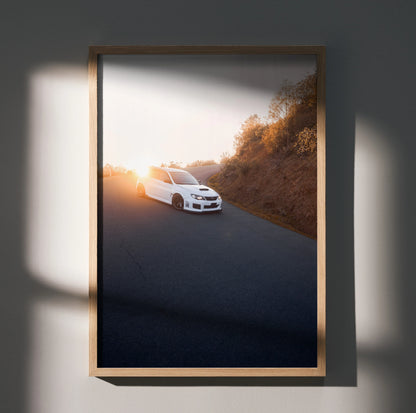 Subaru WRX STI poster featuring white car on winding road at sunset, automotive wall art.