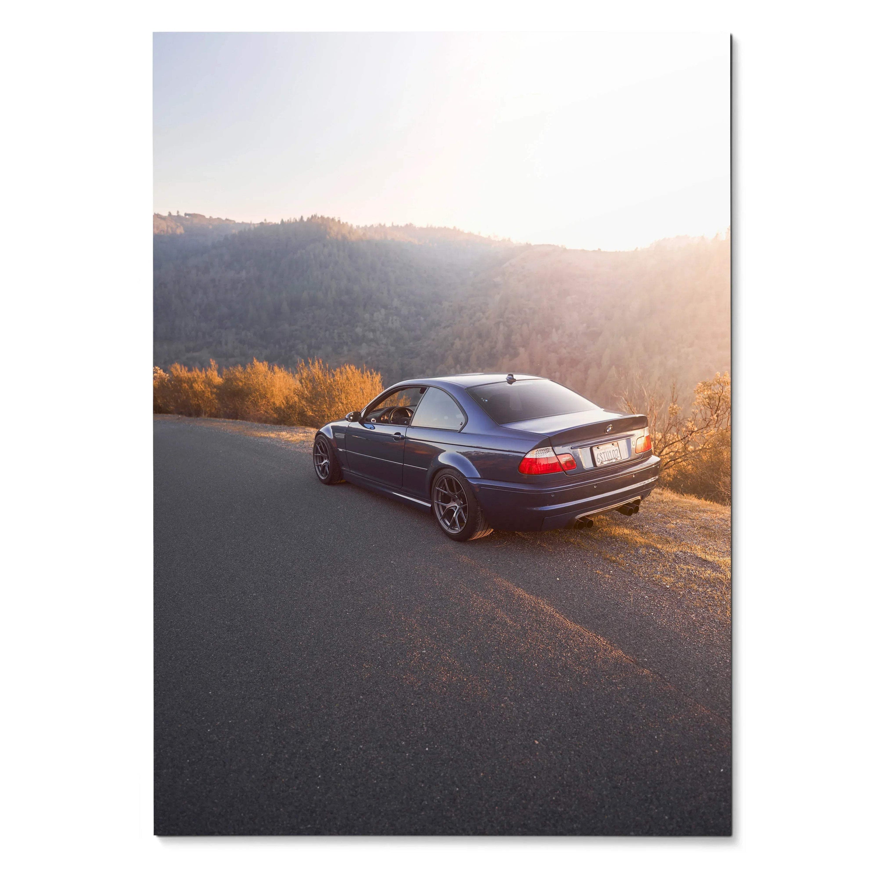 BMW E46 M3 poster showing rear three-quarter view on sunset road, wall art for car enthusiasts.