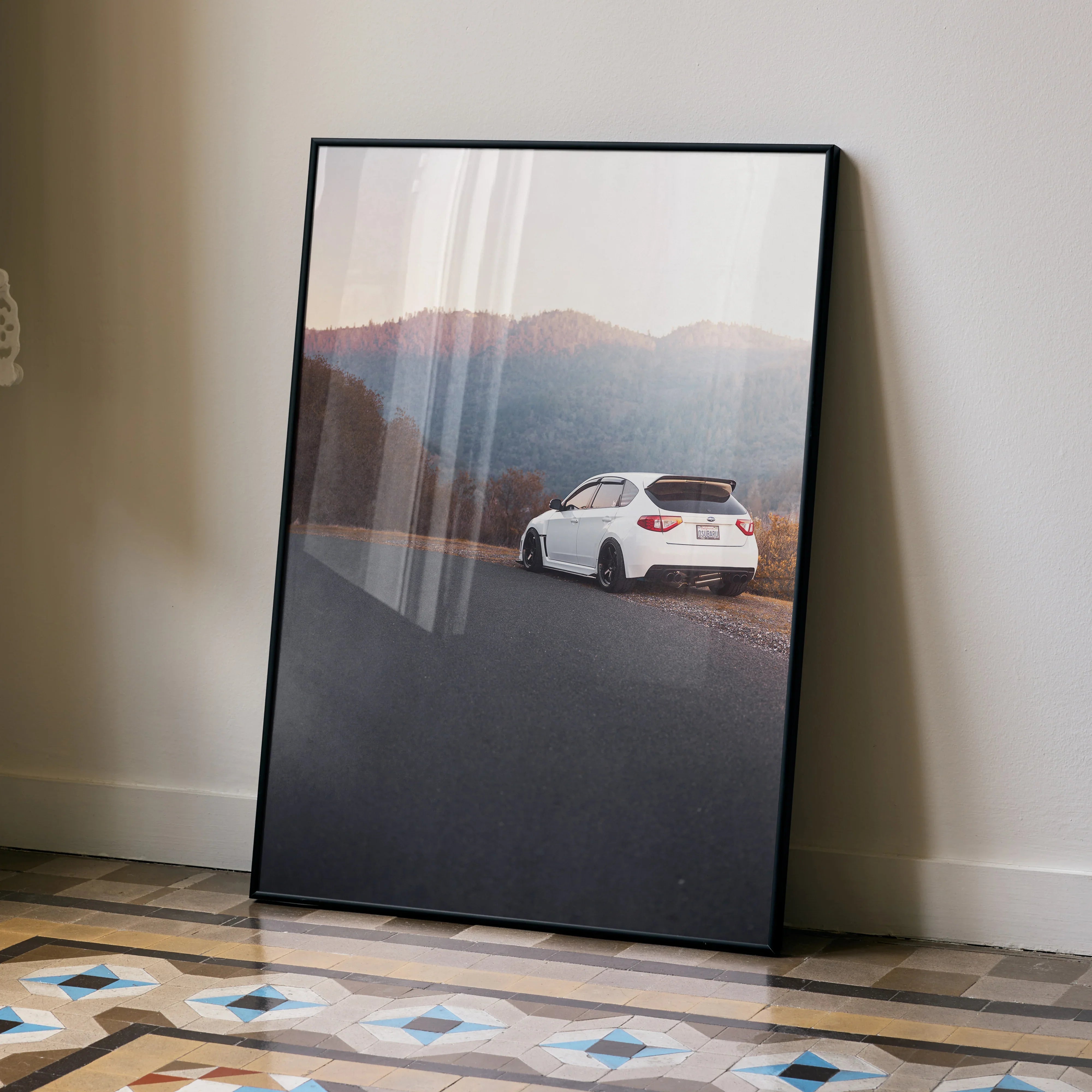 Subaru WRX STI driving on mountain road poster with muted colors wall art in black frame.