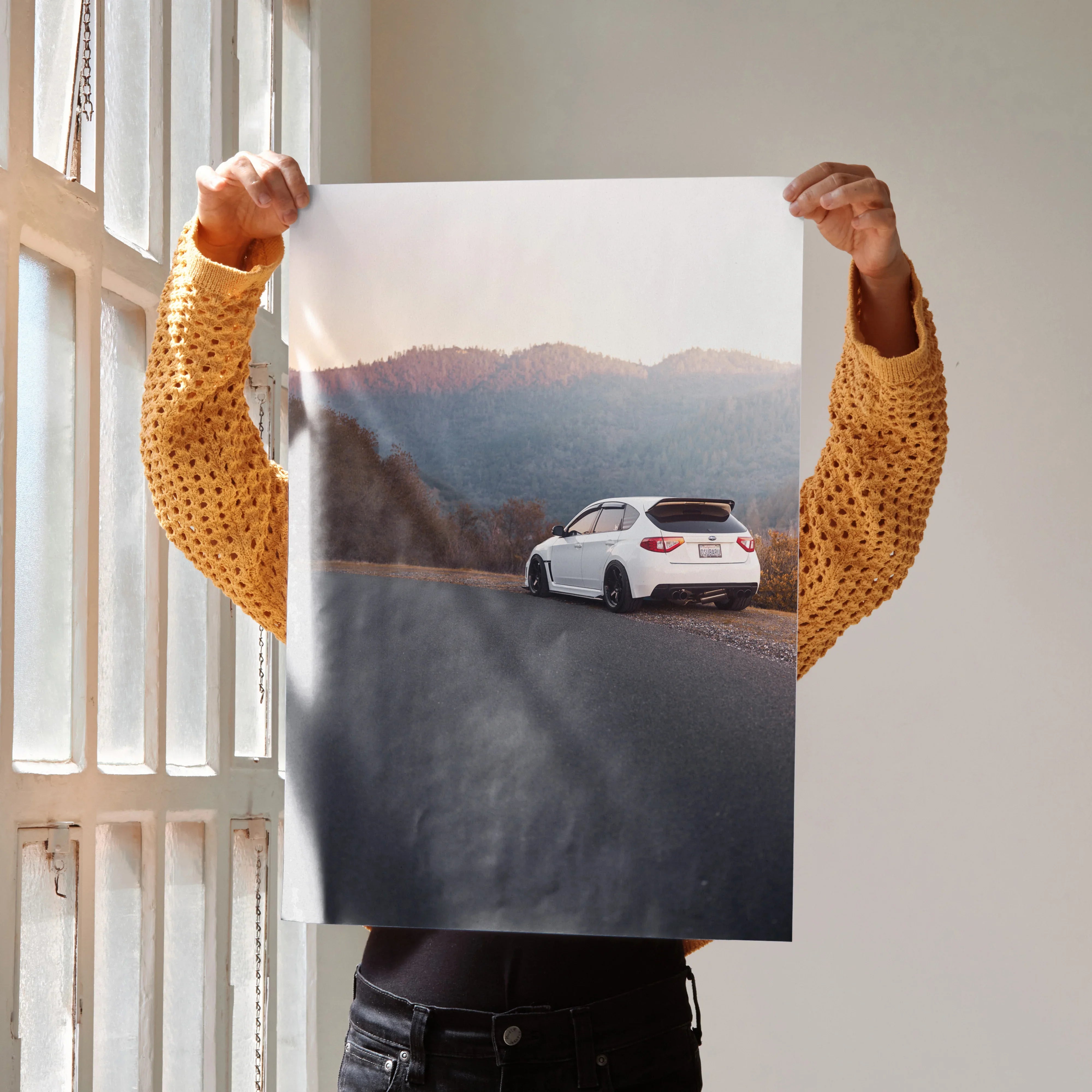 Subaru WRX STI driving on mountain road at sunset poster wall art in neutral tones.