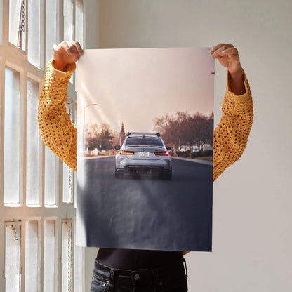 BMW G80 M3 rear view driving on road poster wall art with sunset background.