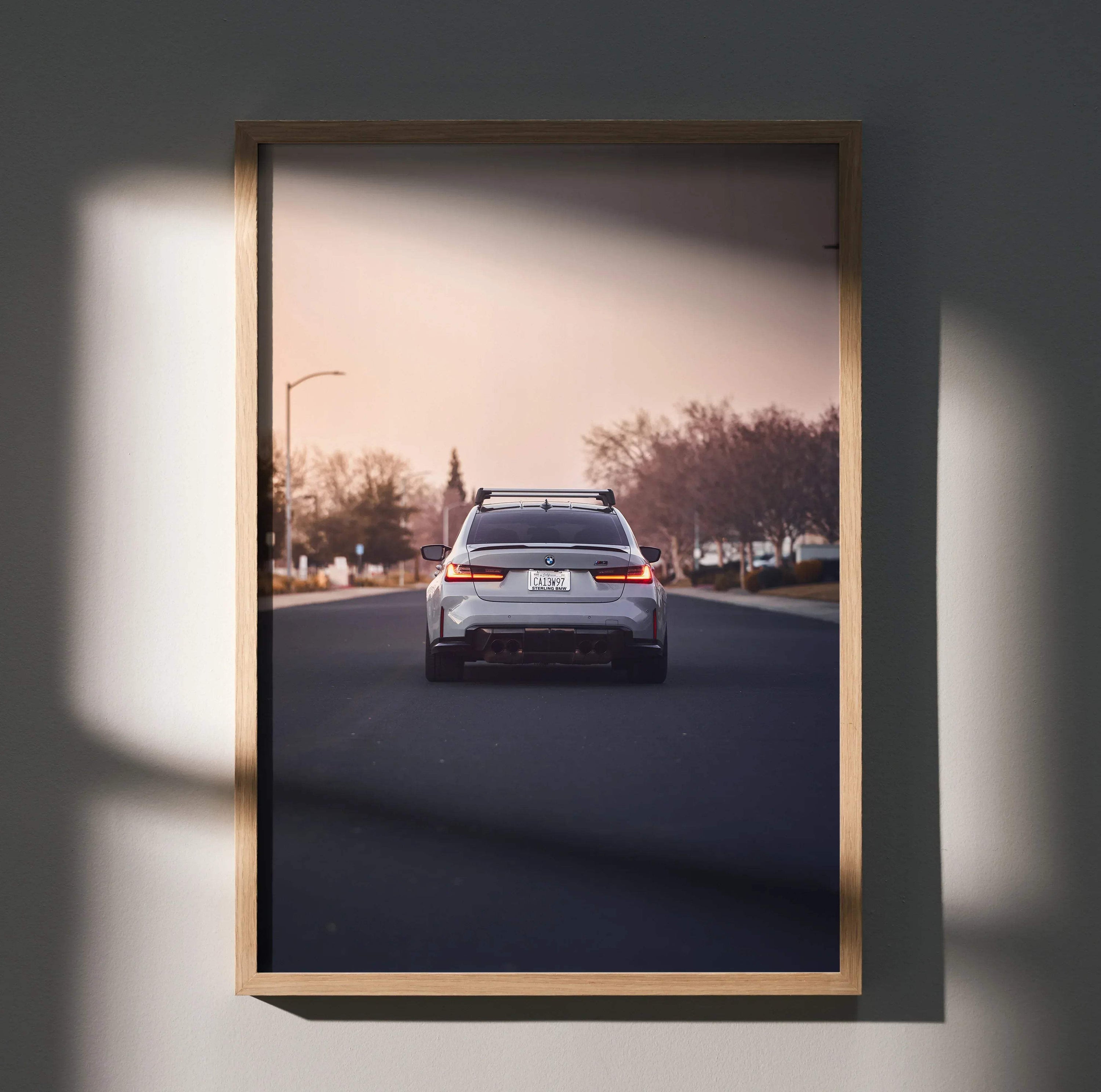 BMW G80 M3 rear view on road wall art poster in wooden frame with soft natural light.