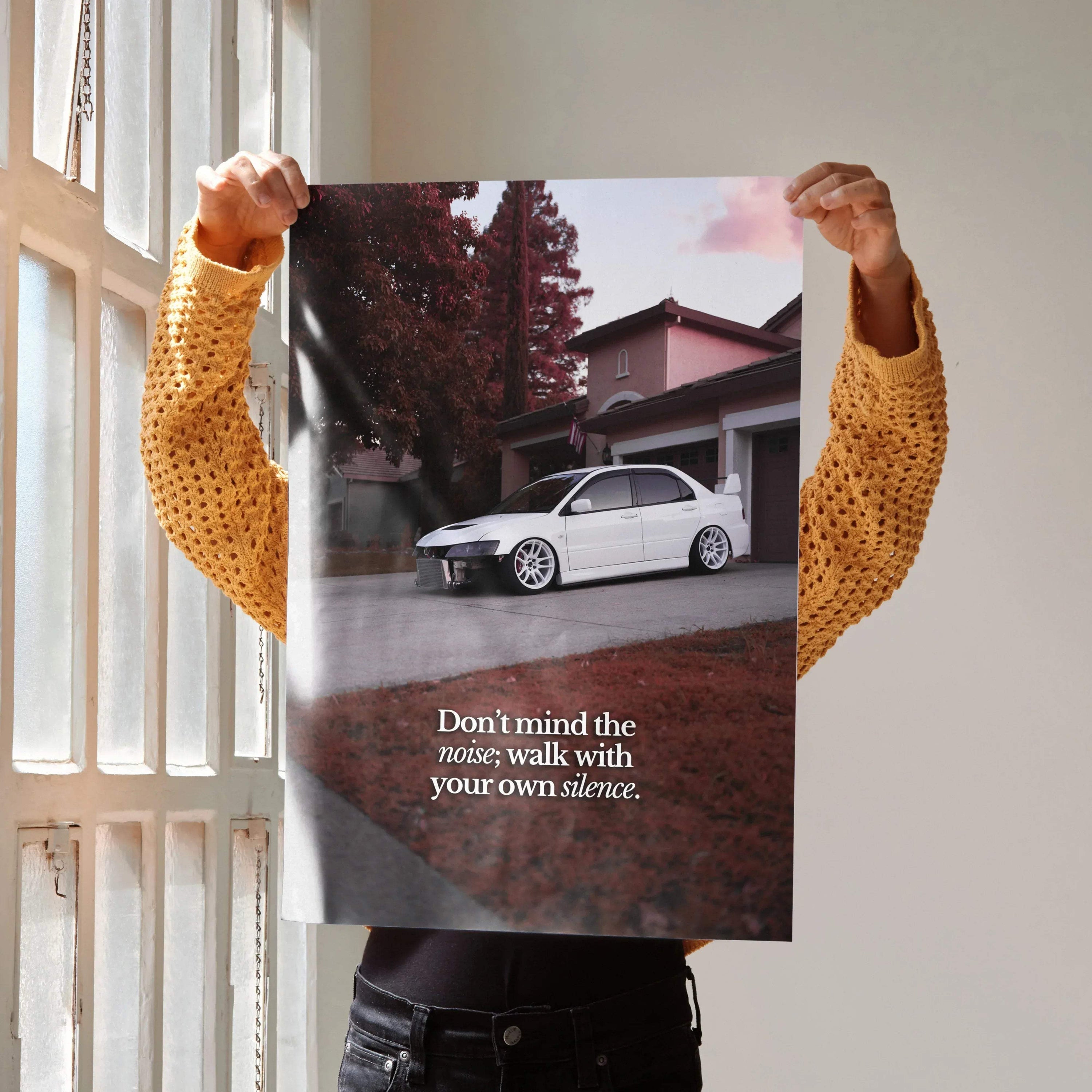 Motivational poster featuring white Mitsubishi Evo 8 parked in front of house with inspiring text wall art.