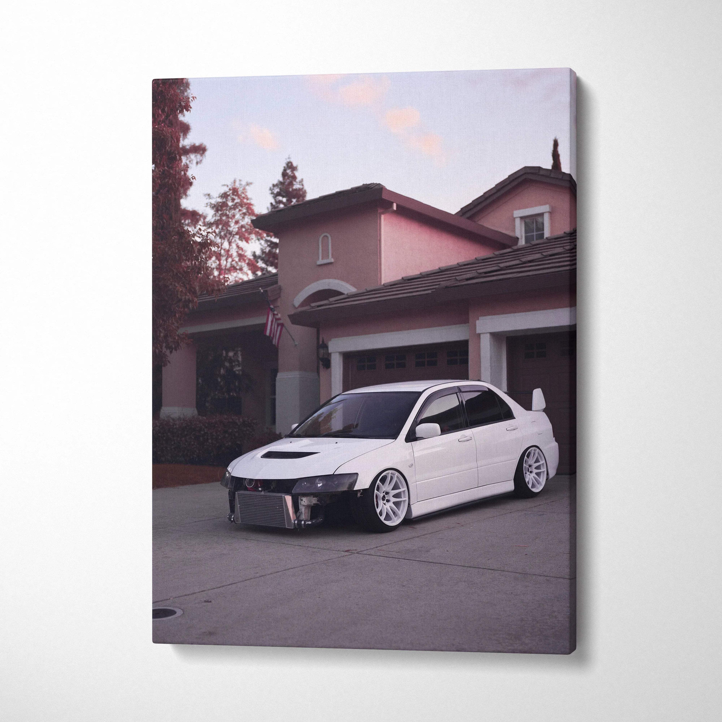 Vertical canvas art wall decor featuring a white Mitsubishi Evo 8 parked in front of a residential garage at dusk.