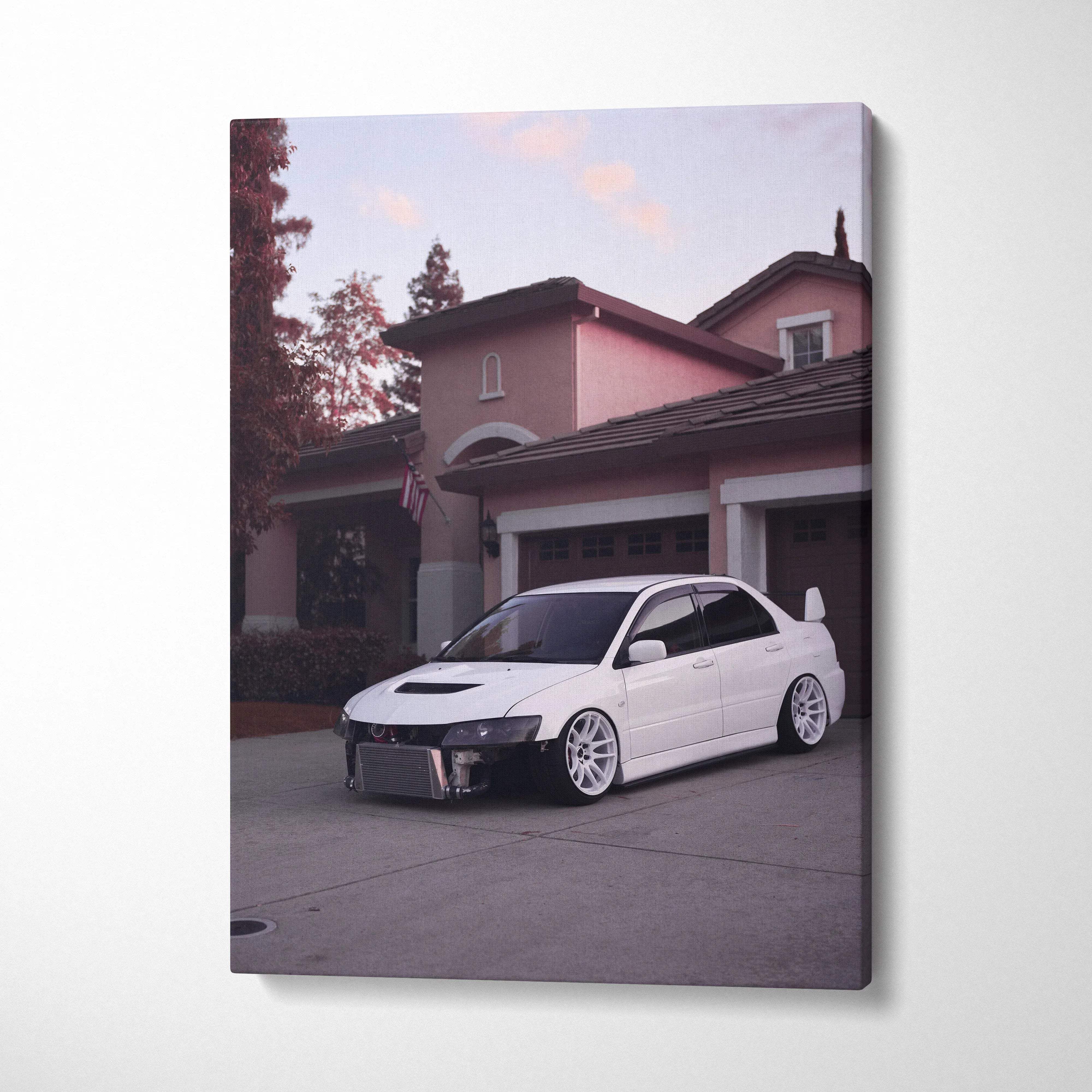 Vertical canvas art wall decor featuring a white Mitsubishi Evo 8 parked in front of a residential garage at dusk.