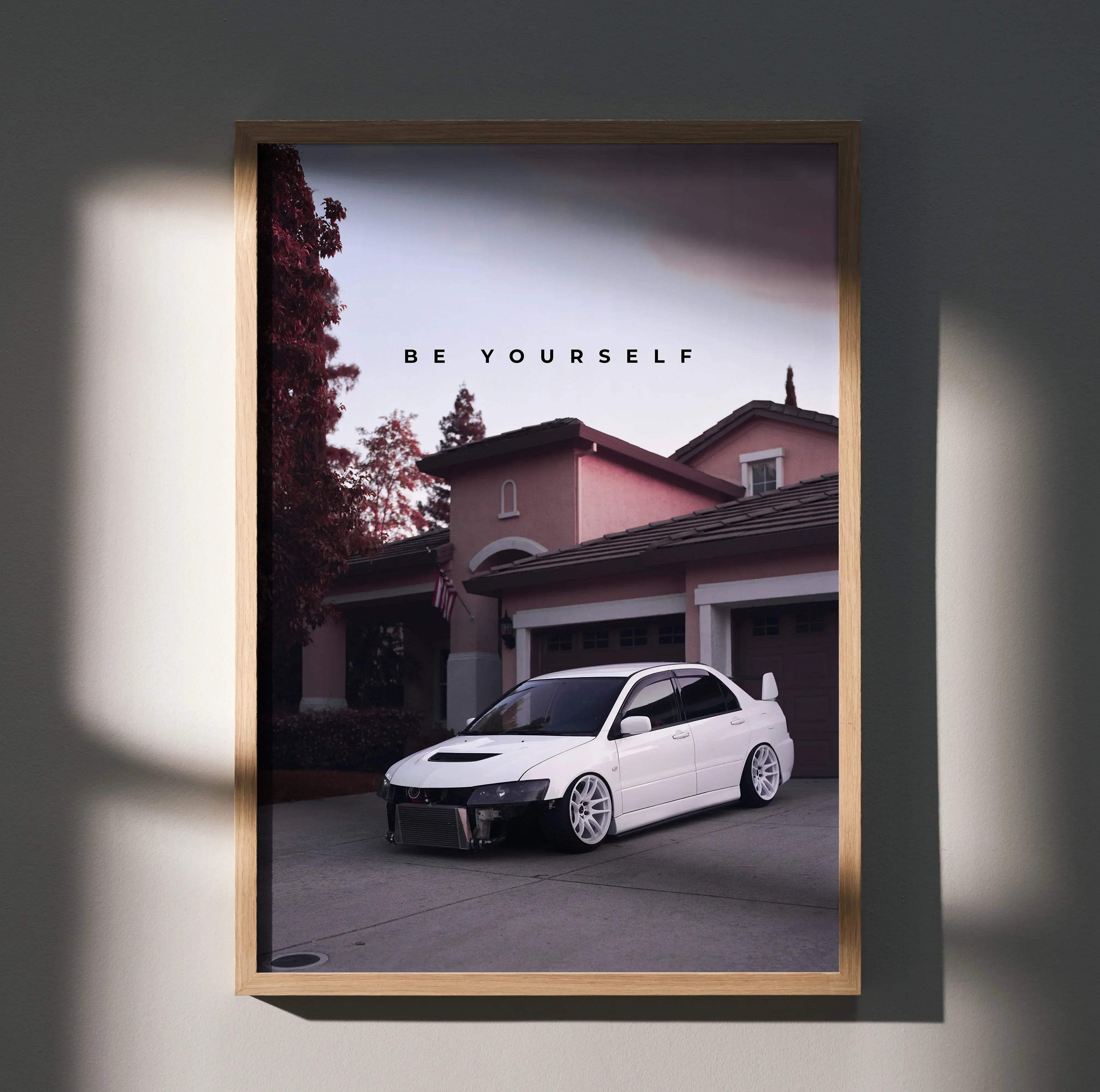 Motivational poster wall art featuring a white Mitsubishi Evo 8 parked in front of a house at dusk with "Be Yourself" text.