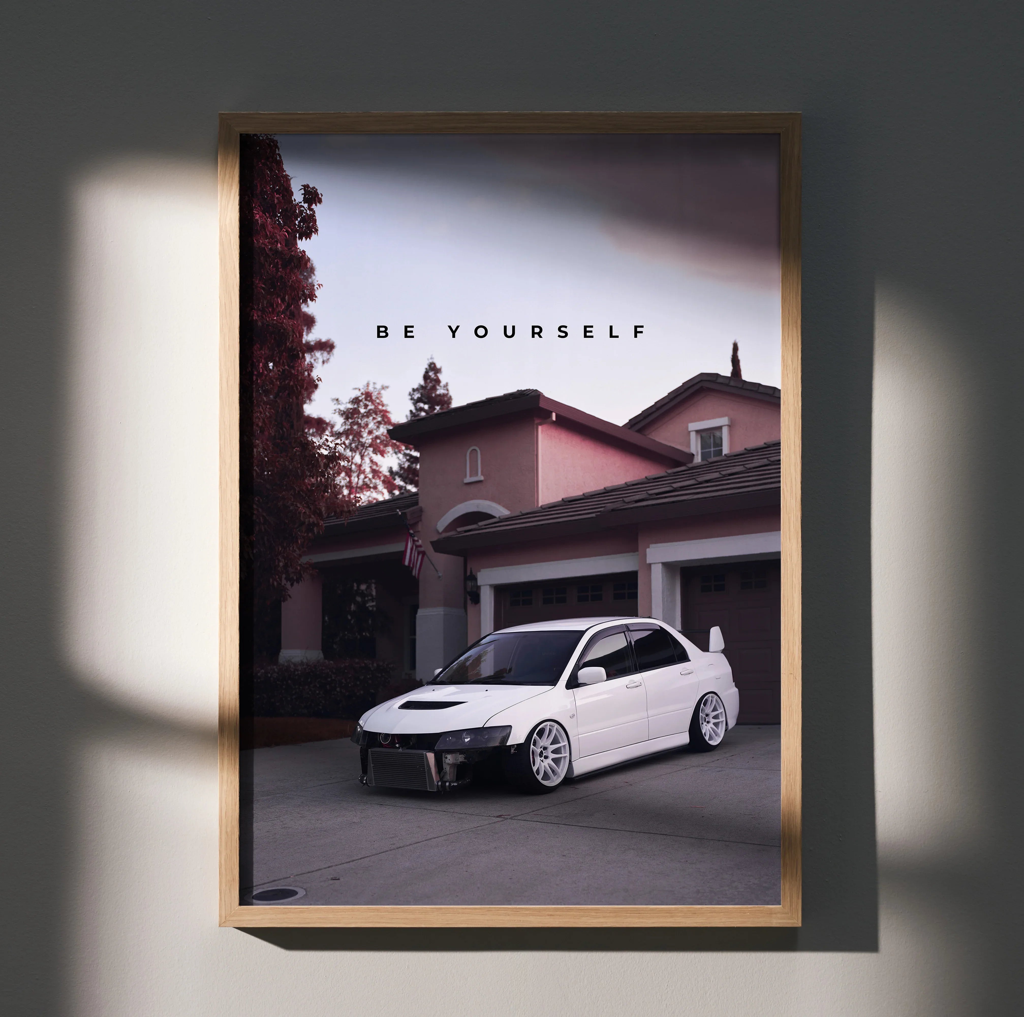 Motivational poster wall art featuring a white Mitsubishi Evo 8 parked in front of a house at dusk with "Be Yourself" text.