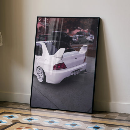 Mitsubishi Evo 8 white sports car rear view poster wall art with black frame leaning on wall.