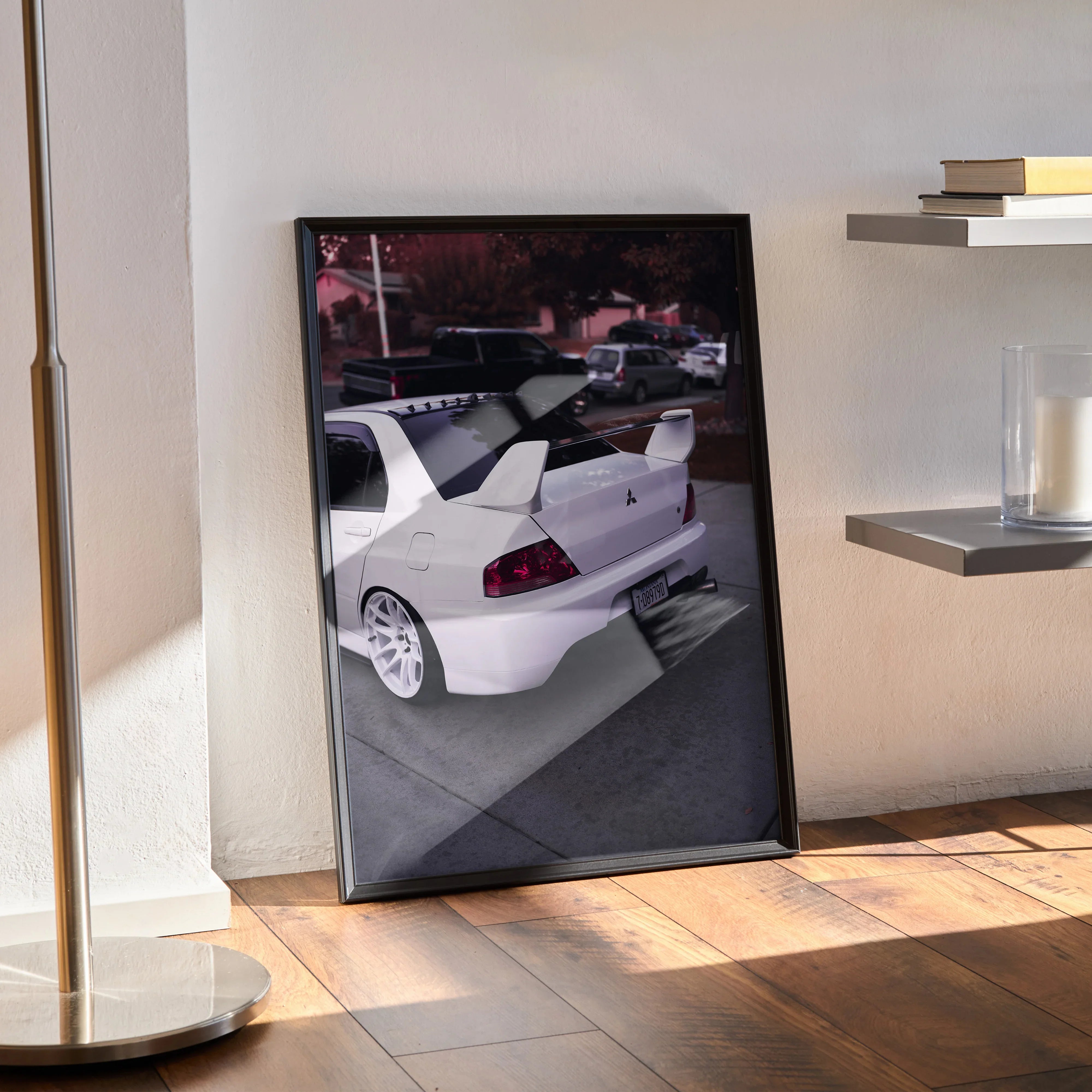 Mitsubishi Evo 8 white sports car poster wall art in black frame leaning on wood floor.