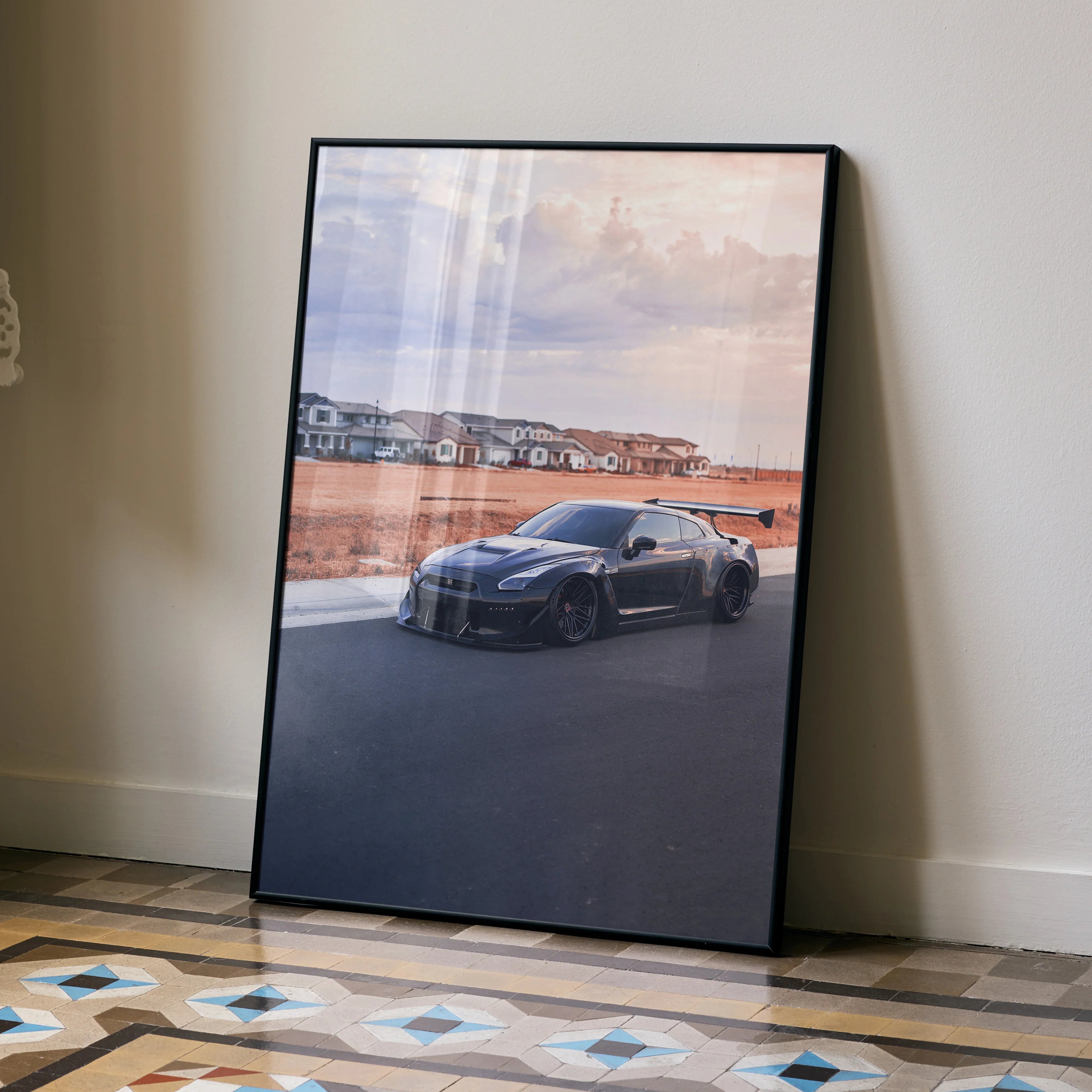 Nissan R35 GTR widebody poster with sunset background leaning against wall, automotive wall art.