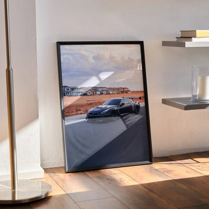 Nissan R35 GTR widebody poster with sunset backdrop, sleek black sports car wall art in black frame.
