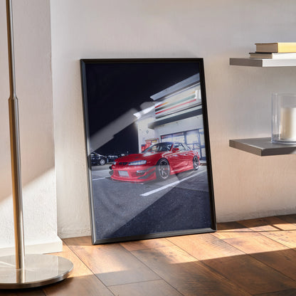 Framed Nissan 240sx S14 Kouki red sports car poster leaning on floor with modern interior wall art.
