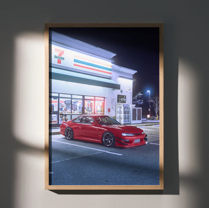 Red Nissan 240sx S14 Kouki parked in front of a brightly lit convenience store, poster wall art in wooden frame.