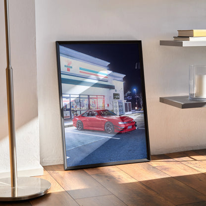 Red Nissan 240sx S14 Kouki poster leaning against wall, automotive wall art with night city background.