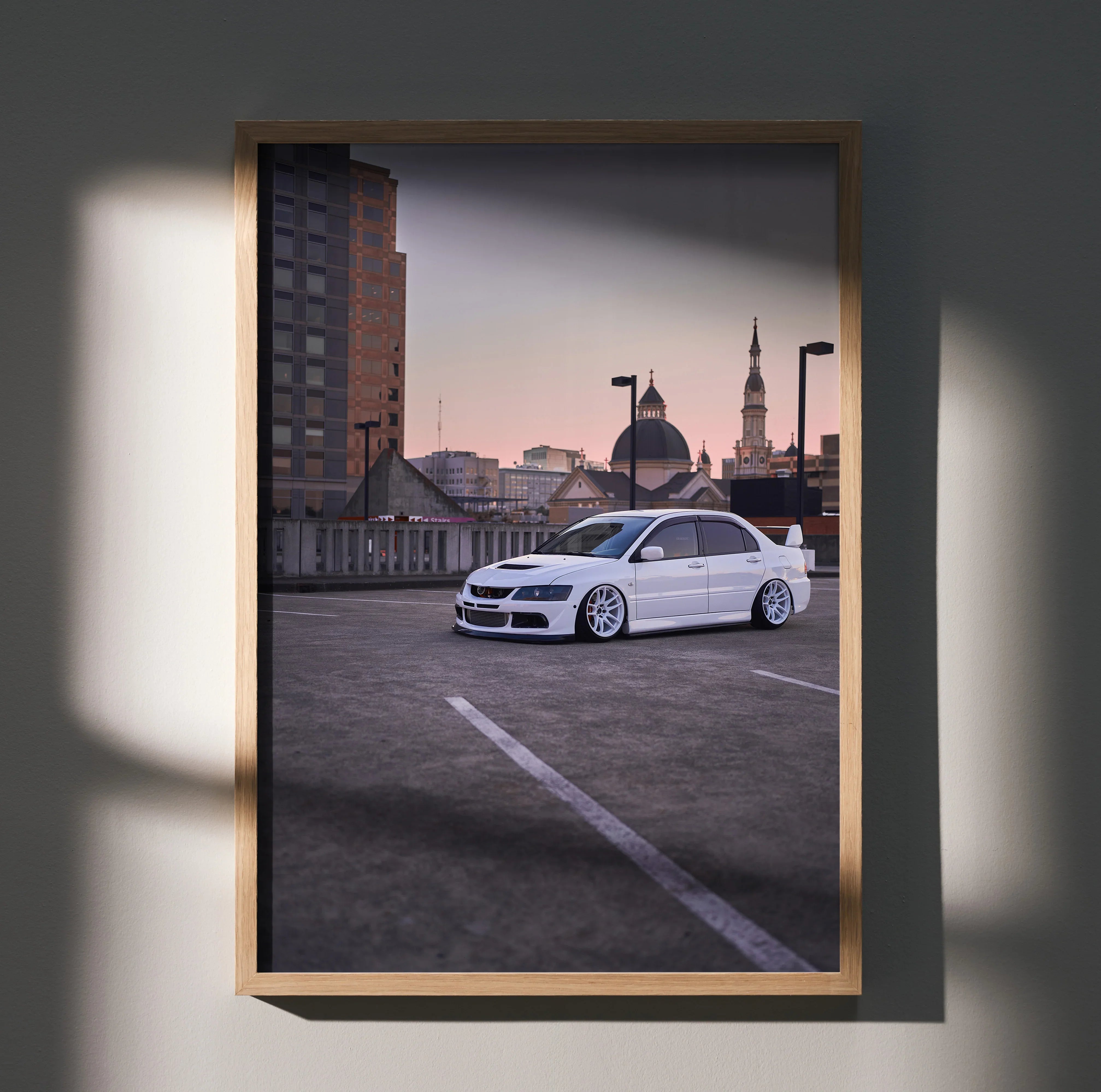 Mitsubishi Evo 8 white car poster framed wall art with urban rooftop background and soft lighting.