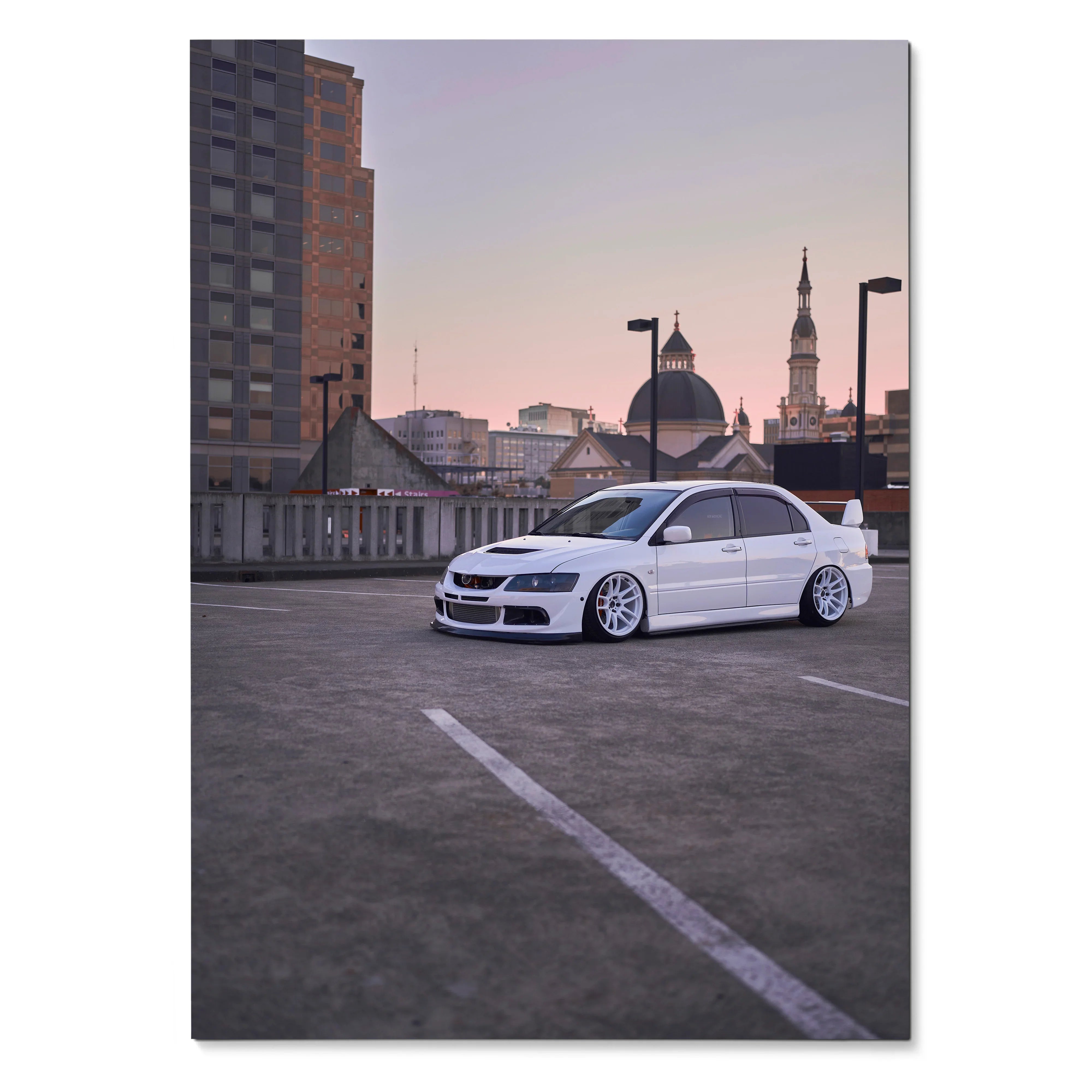 Mitsubishi Evo 8 parked on rooftop at sunset poster wall art with city skyline background.