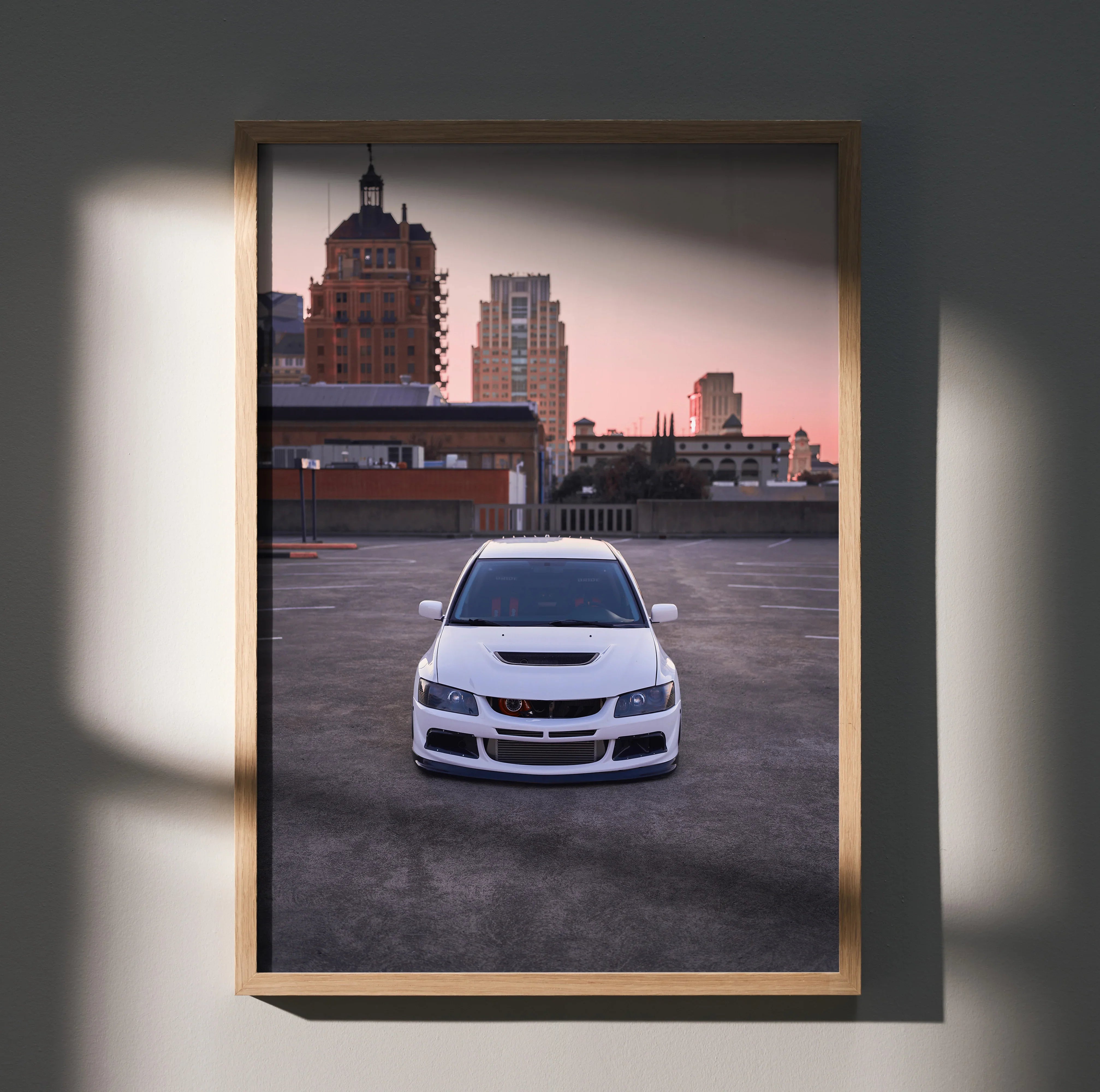 Mitsubishi Evo 8 white sports car against city skyline at sunset poster wall art.