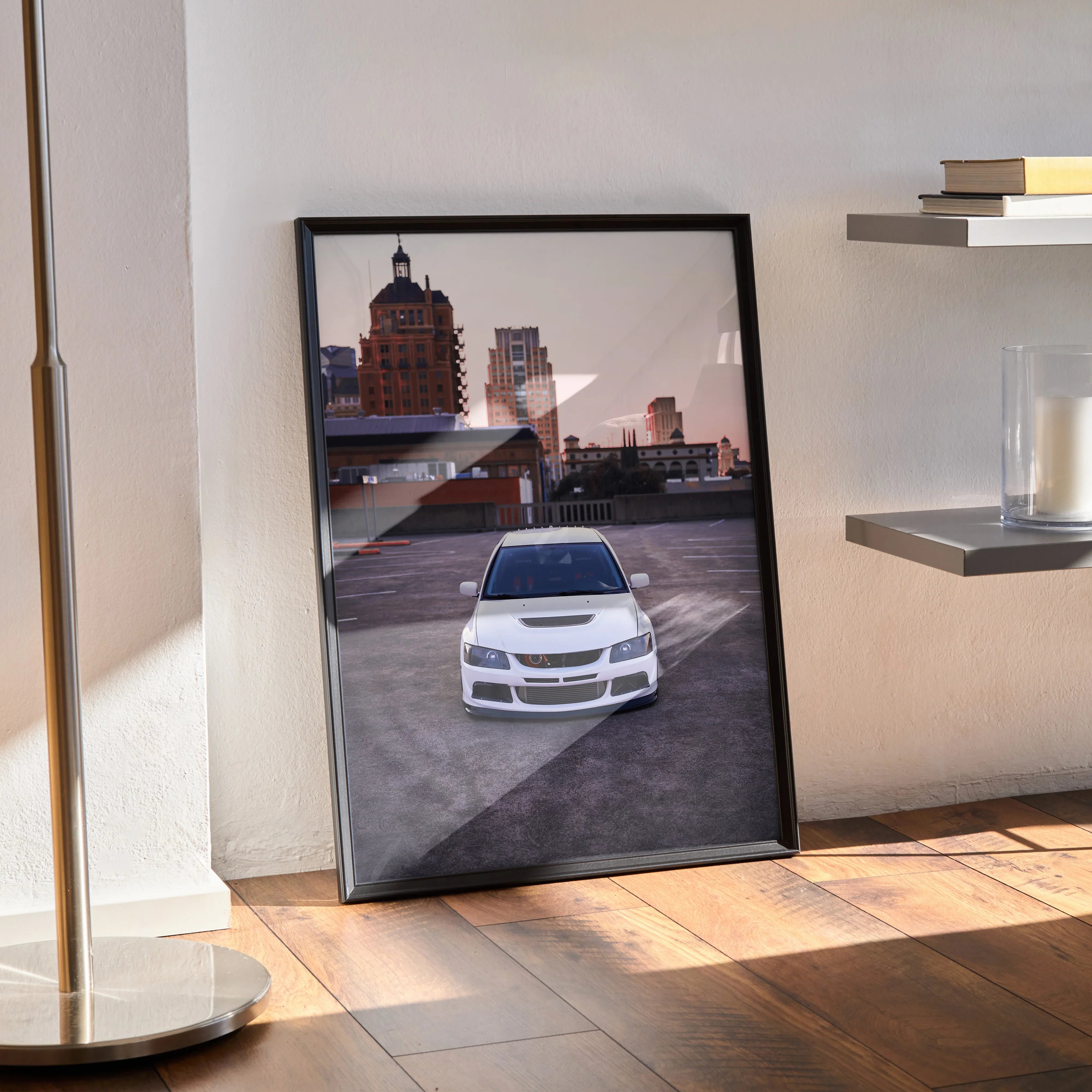 Mitsubishi Evo 8 white car poster leaning on floor with city skyline wall art in black frame.