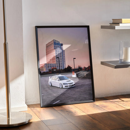 Mitsubishi Evo 8 poster with urban sunset background, framed wall art standing on hardwood floor.